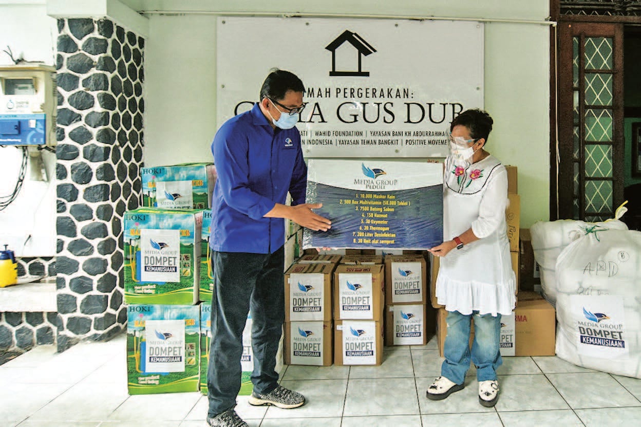 DKMG MENYERAHKAN DONASI: Ketua Dompet Kemanusiaan Media Group (DKMG) Ali Sadikin (kiri) secara simbolis menyerahkan donasi pada perwakilan G