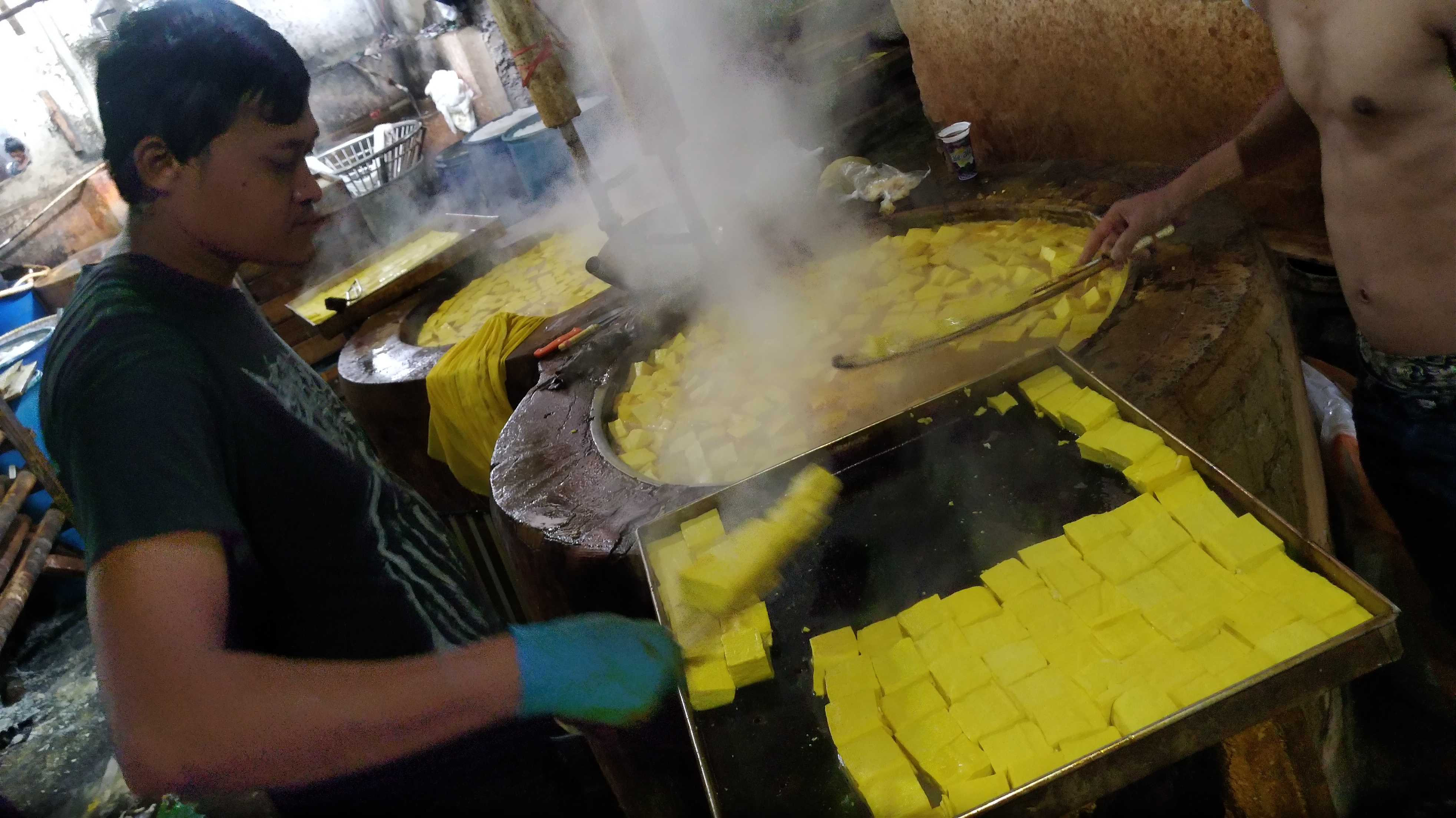 ekerja mengangkat tahu dari panci setelah dilakukan proses pewarnaan di salah satu tempat produksi tahu di Kampung Cireyod, Lembang.