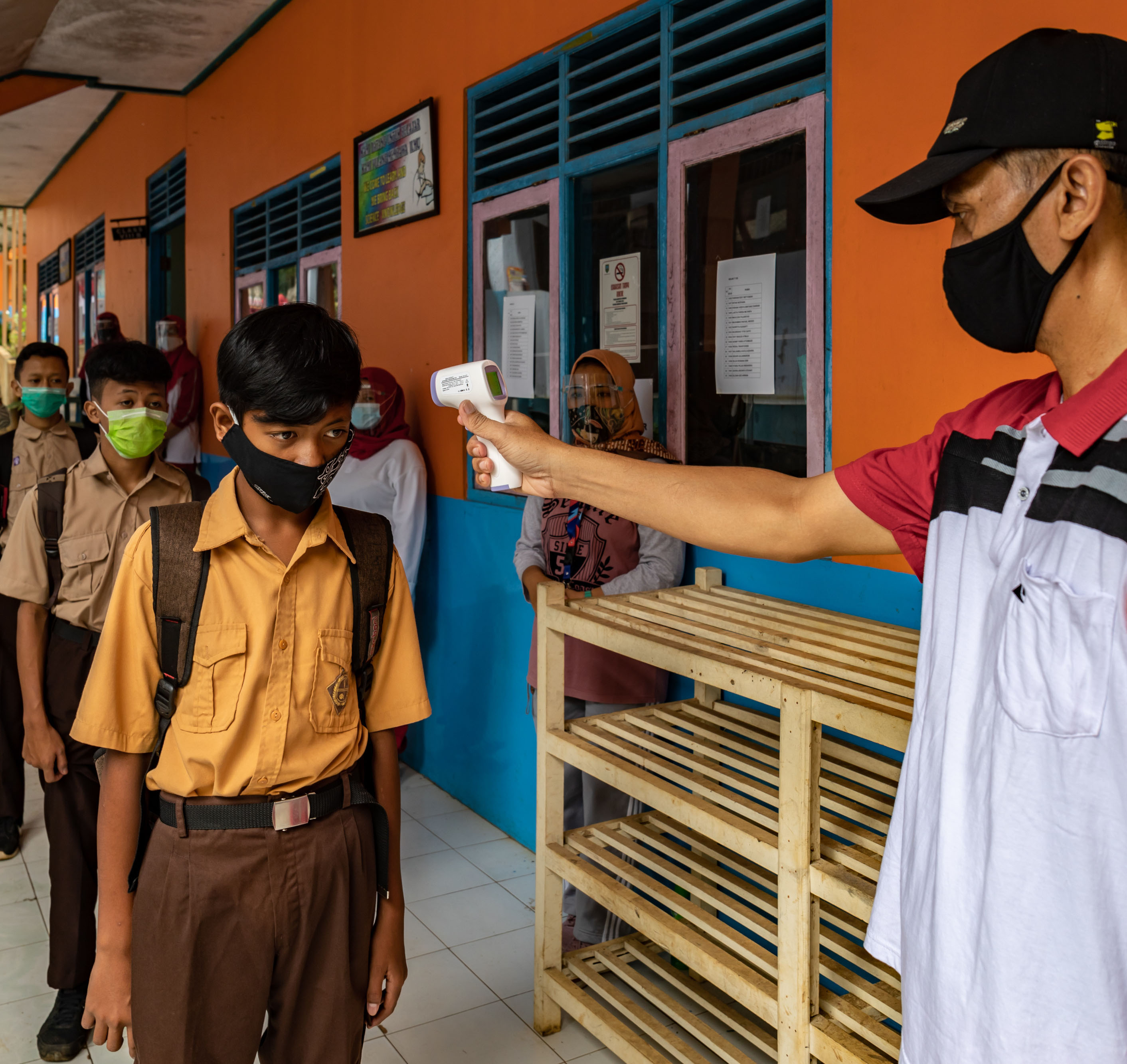 Guru memeriksa suhu tubuh siswa yang akan mengikuti pembelajaran tatap muka di SMPN 6 Lerep Satu Atap, Ungaran, Semarang, Jumat (27/11).
