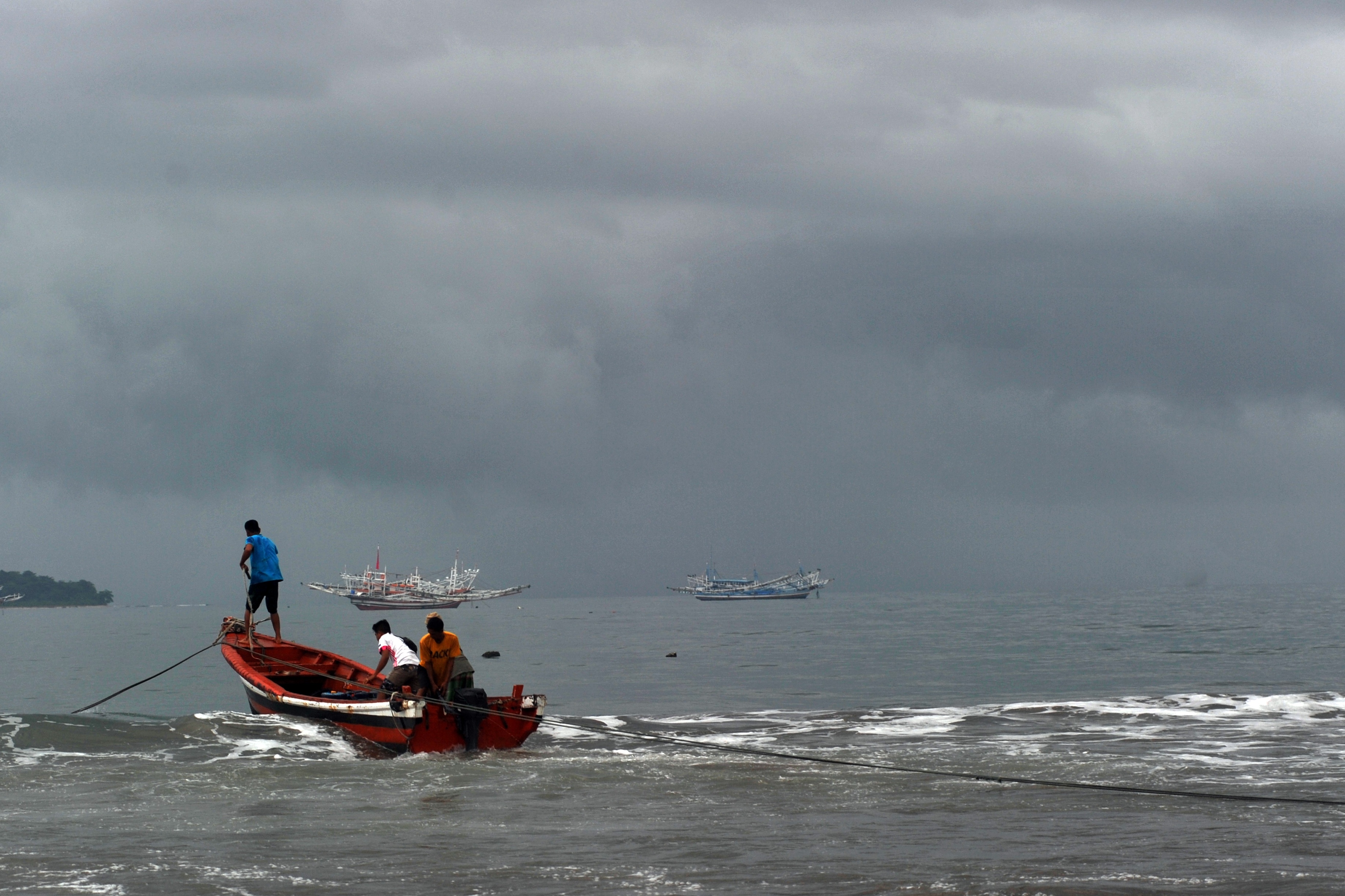 Nelayan memindahkan bahan bakar untuk kapal bagan saat langit berawan di Pantai Pasie Nan Tigo, Padang, Sumatra Barat, beberapa waktu lalu.