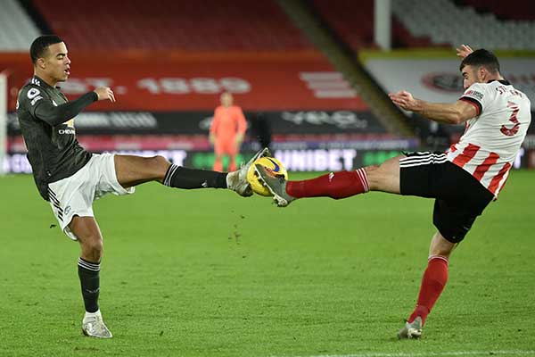 Striker Manchester United Mason Greenwood (kiri) dan bek Sheffi eld United Enda Stevens berebut bola