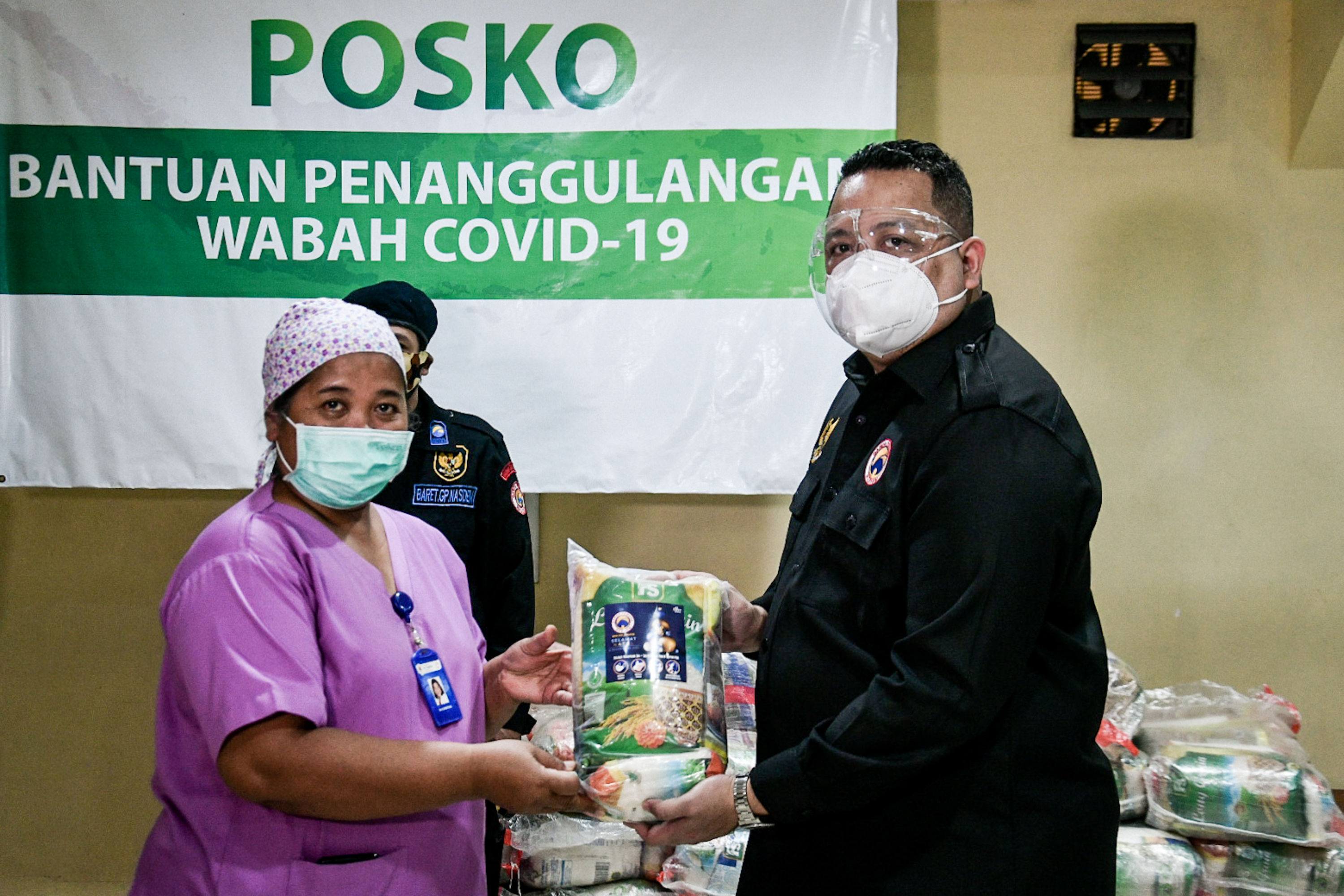 Garda Pemuda Nasdem Nova Harivan Paloh (kanan) secara simbolis memberikan bantuan  pada Kepala Sekretariat dan Rumah Tangga RS St Carolus