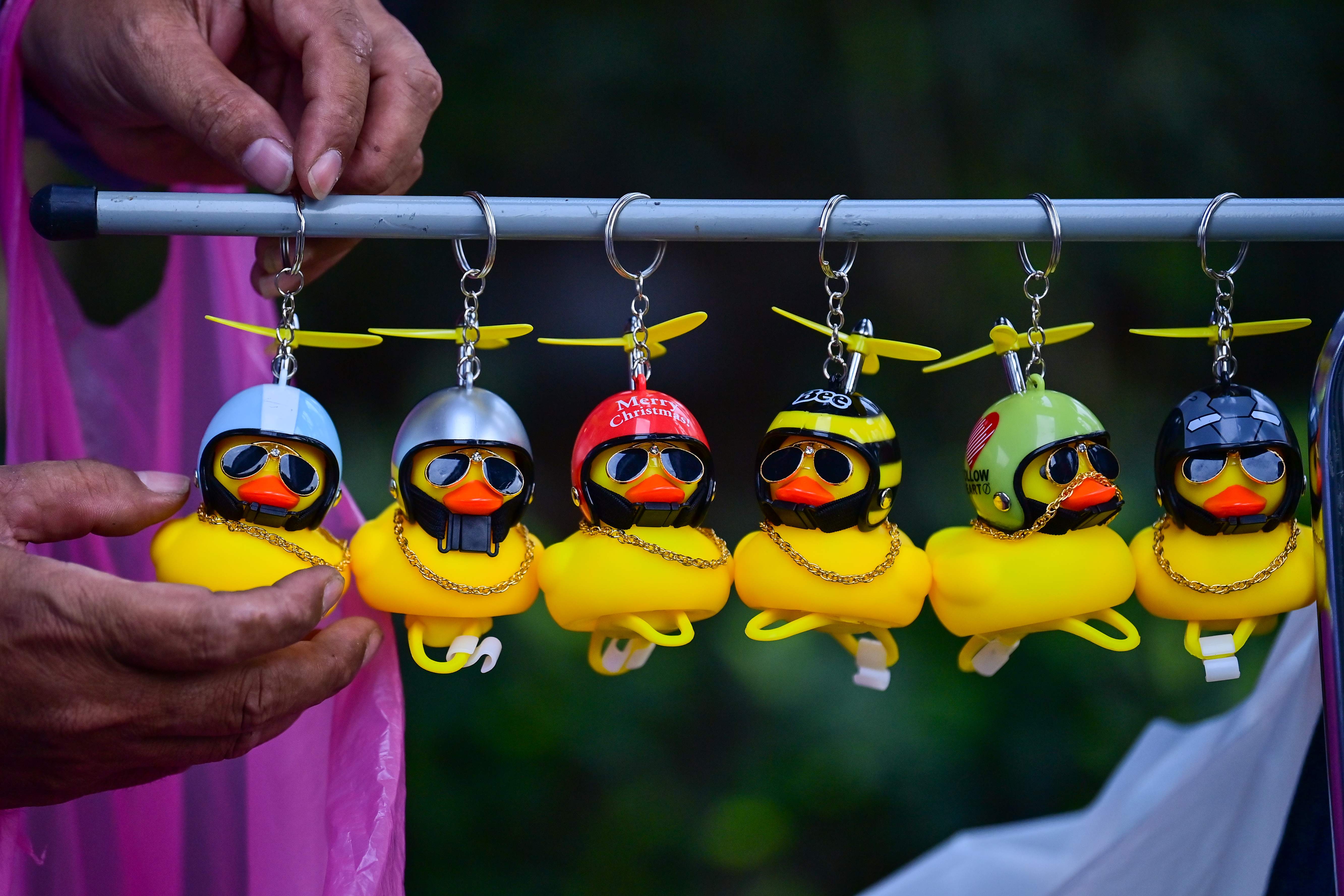 Gantungan kunci bebek karet dijual di tengah demonstrasi di Bangkok, Thailand.
