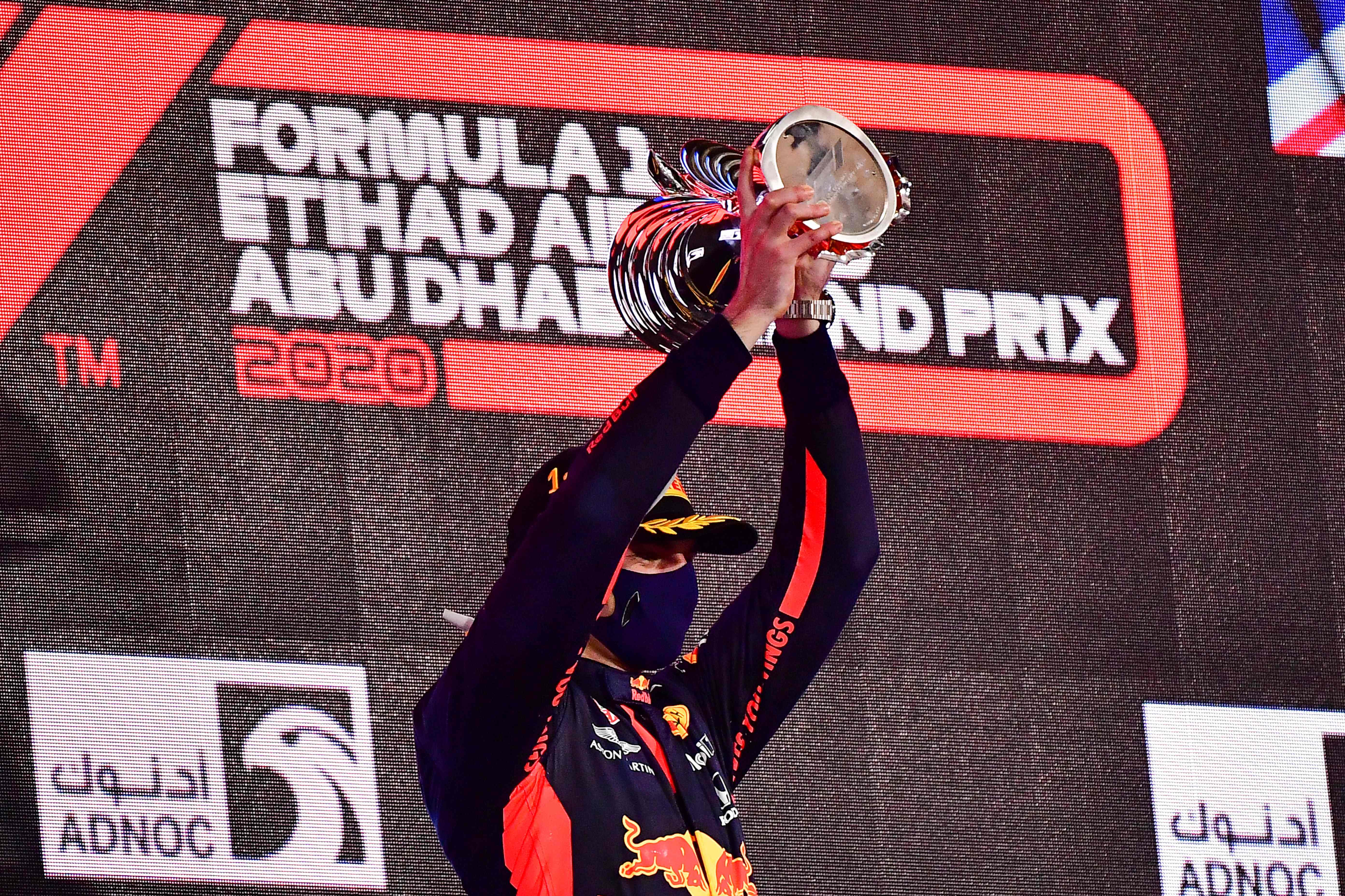 Pembalap Red Bull Max Verstappen mengangkat trofi juara GP Abu Dhabi.