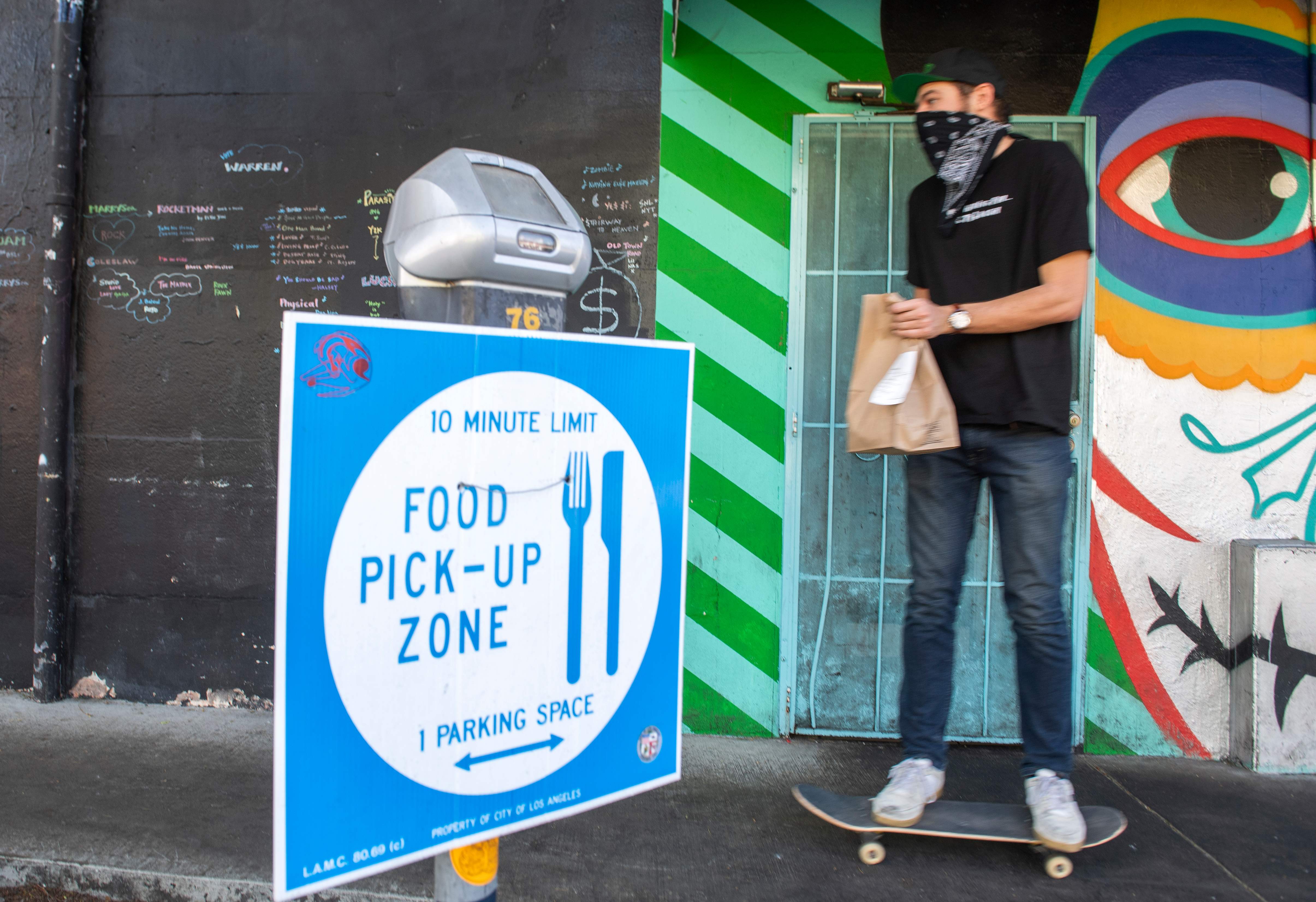 Seorang pria mengambil makanan dari zona pengambilan makanan di Los Angeles, AS, Selasa (8/12).