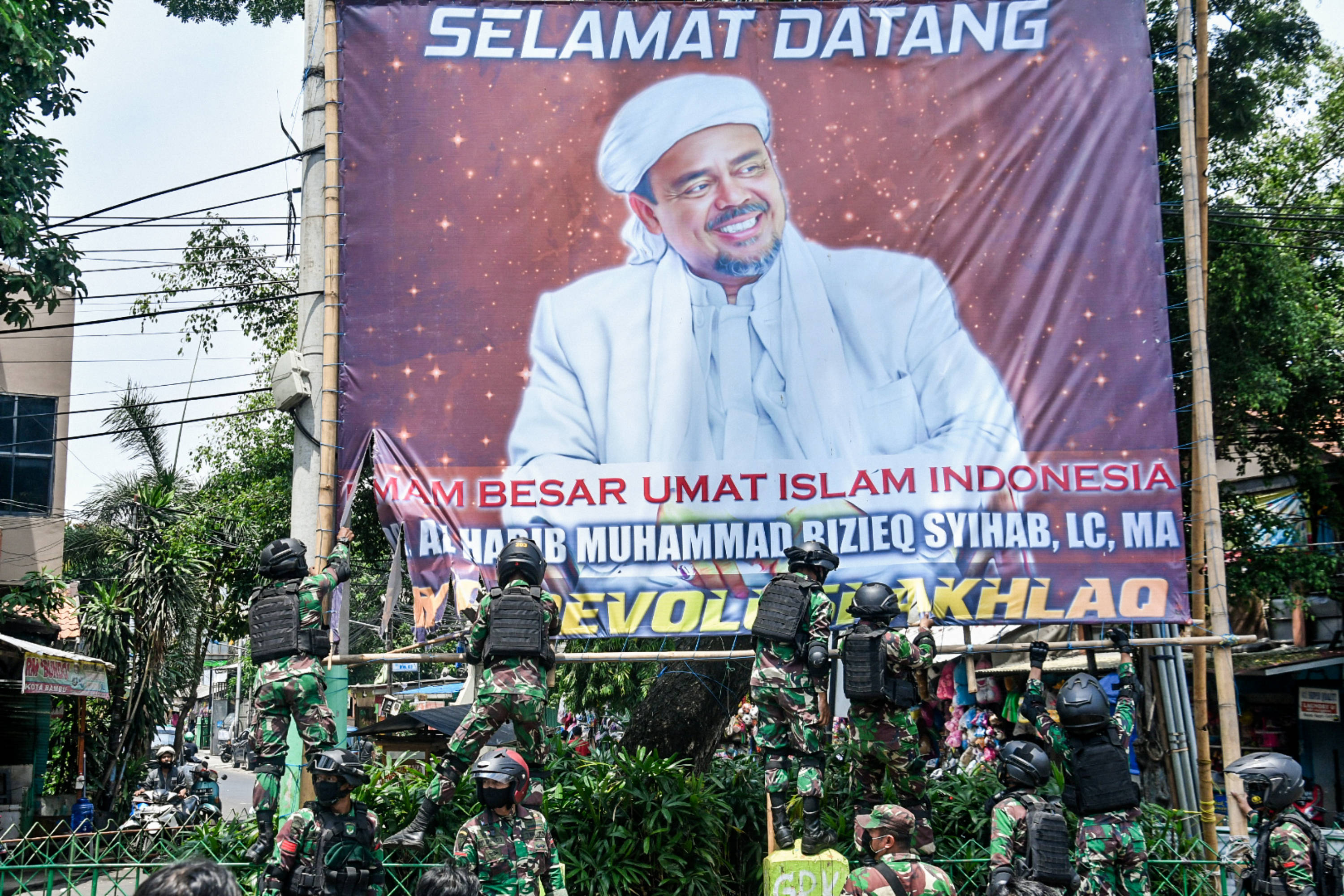 Anggota TNI mencopot baliho bergambar Imam Besar FPI Rizieq Shihab di kawasan Tanah Abang, Jakarta.