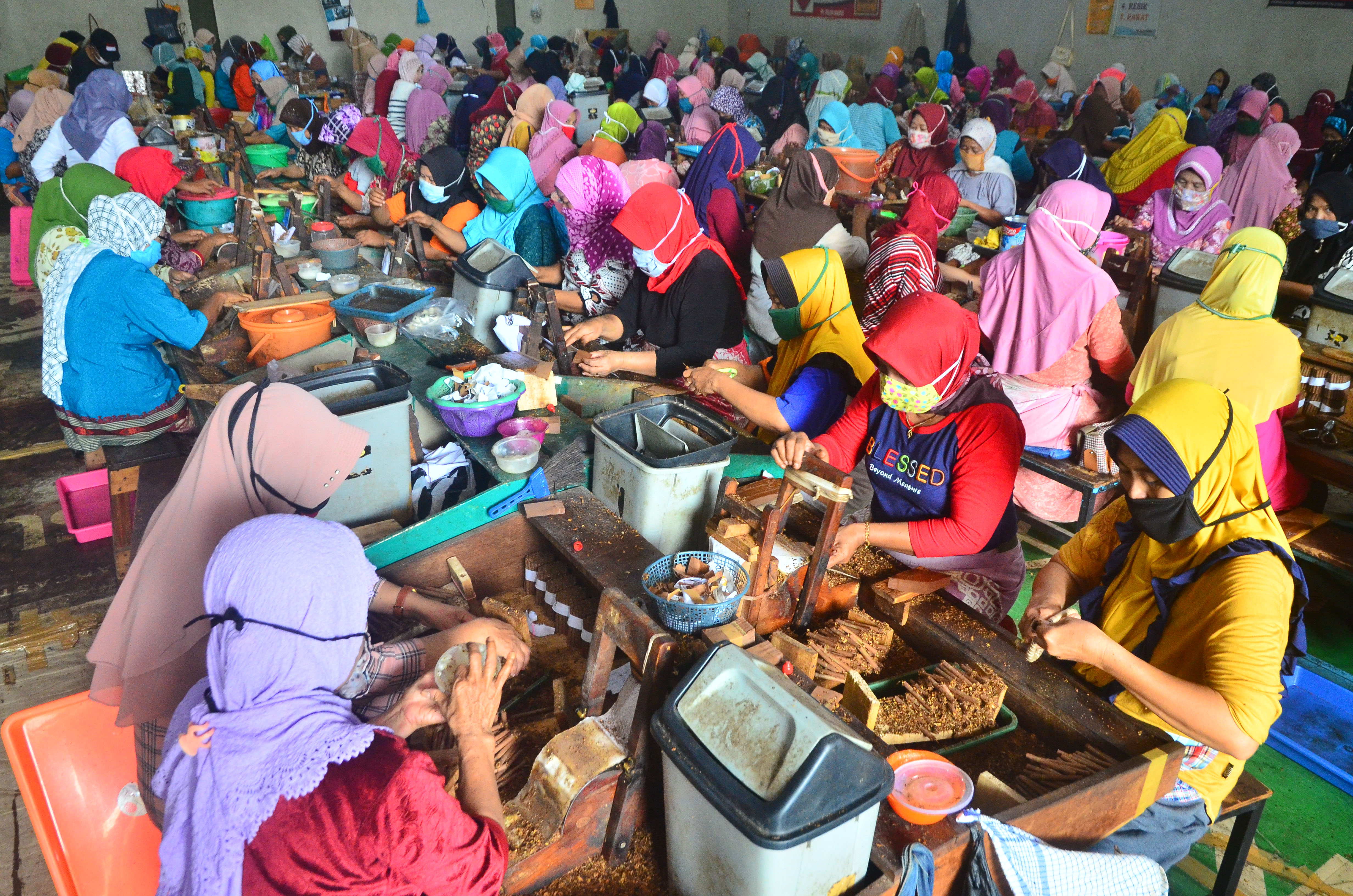 Pekerja tengah melinting tembakau untuk rokok jenis sigaret kretek