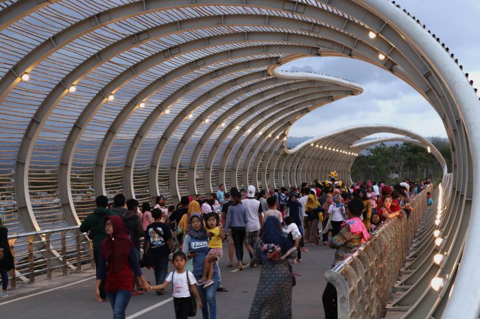 Wisatawan menikmati suasana jembatan lintas di Pantai Marina Boom, Banyuwangi, Jawa Timur, Minggu (3/11/2019). 