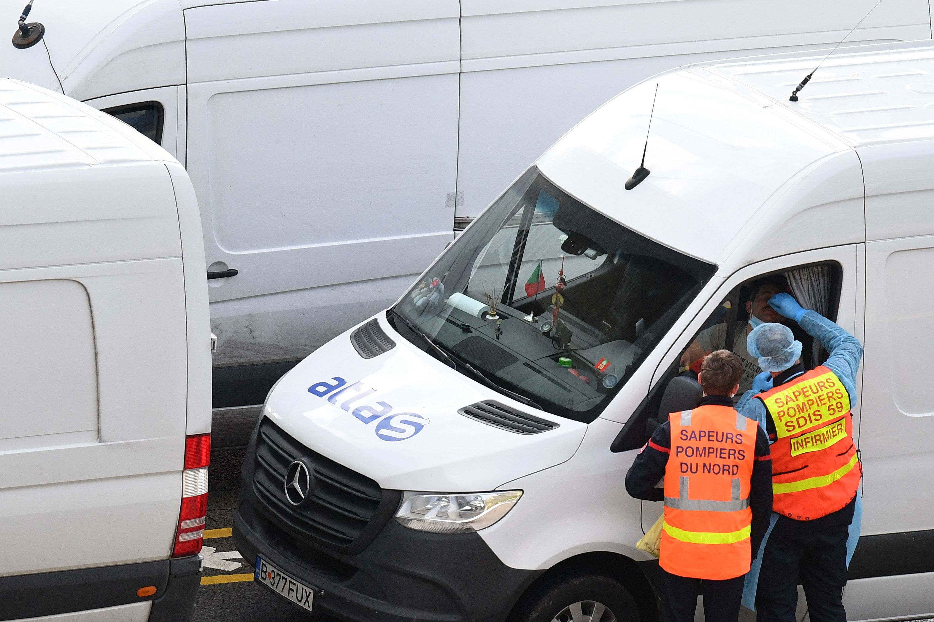 Petugas melakukan tes covid-19 pada pengendara di pelabuah Dover, Timur Laut Inggris, Kamis (24/12).