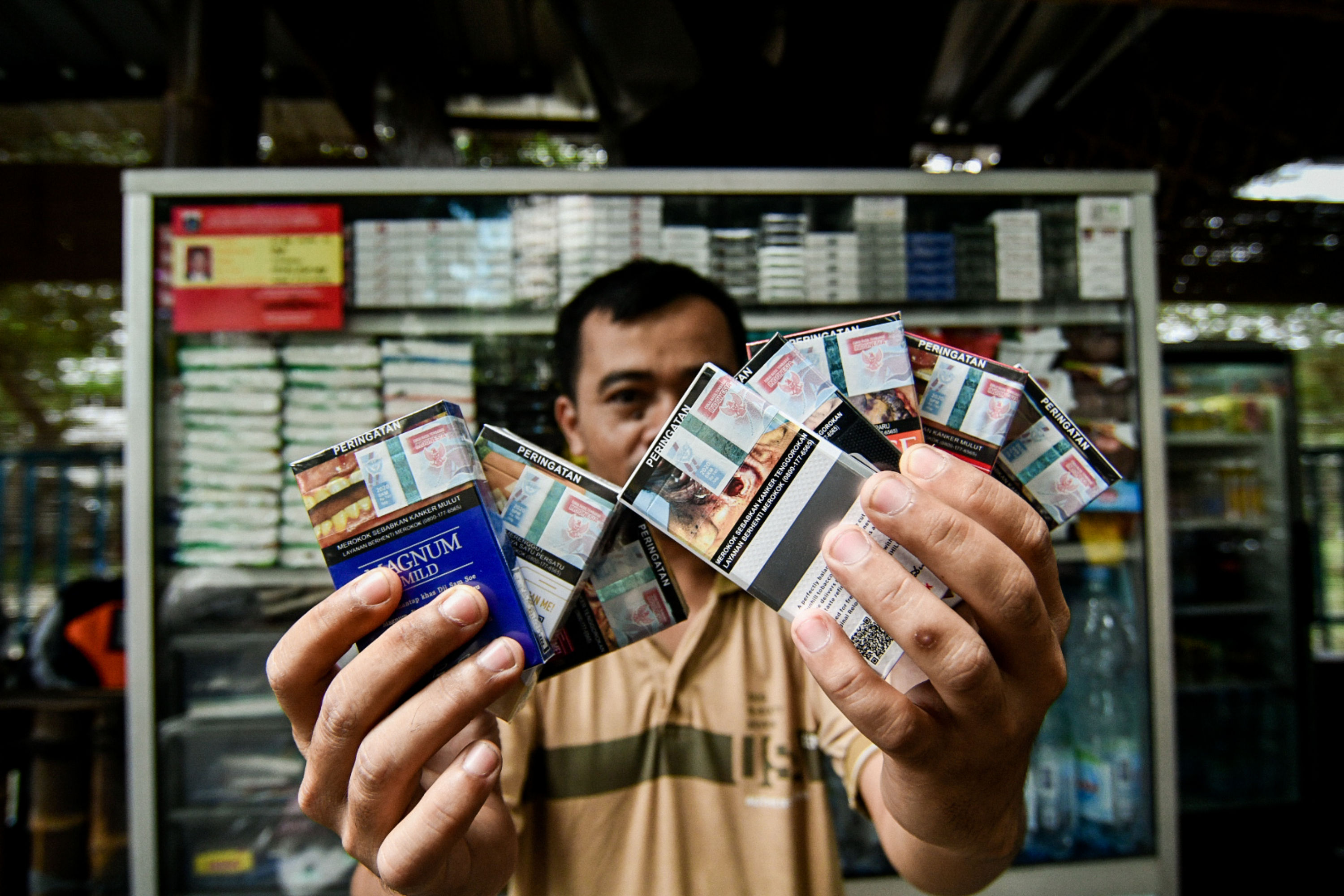 Pedagang menunjukkan bungkus rokok bercukai di Jakarta, kemarin. Menkeu Sri Mulyani Indrawati resmi menetapkan penaikan cukai rokok 12,5%.