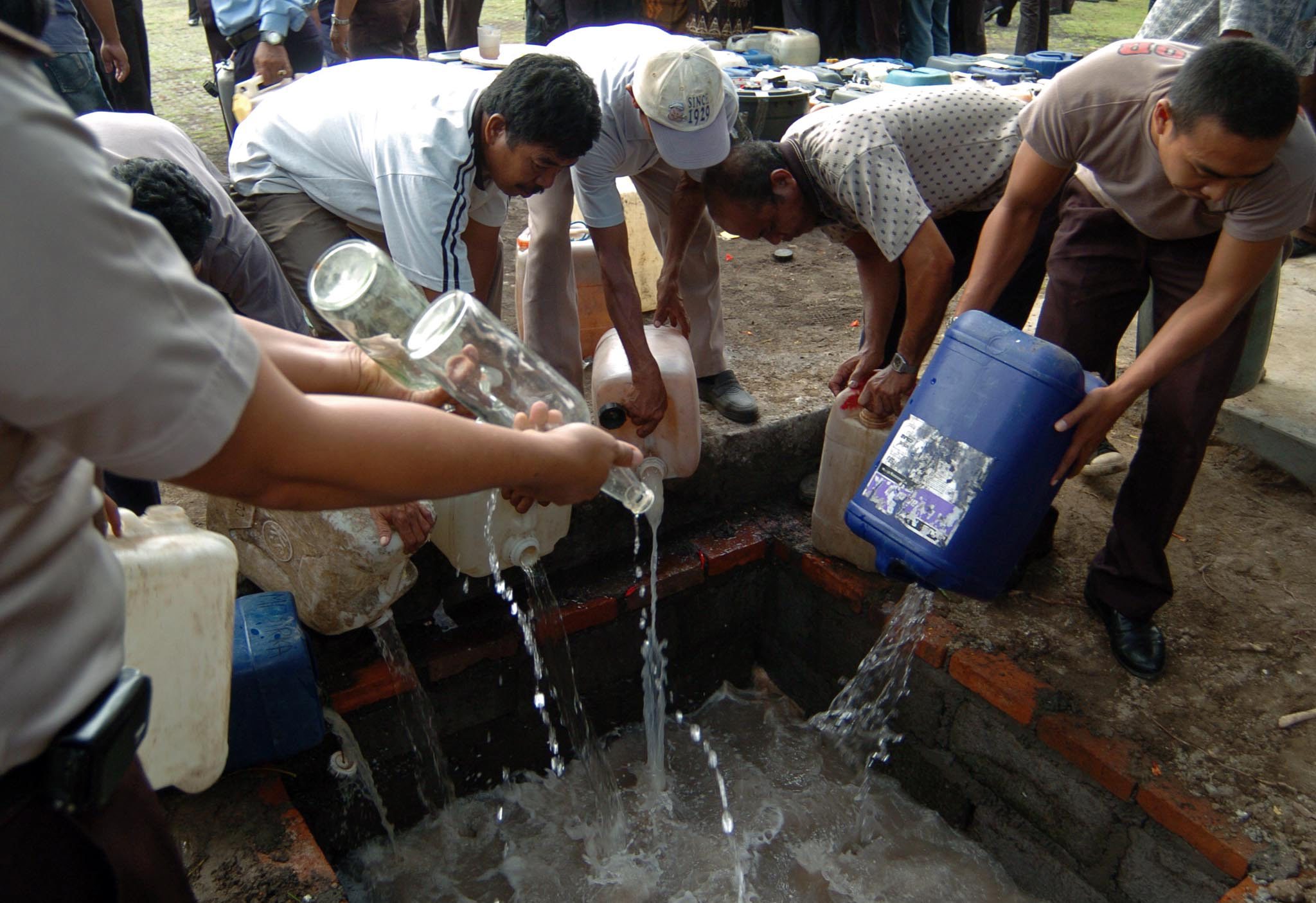 Petugas membuang minuman keras (miras) hasil operasi oleh Mapolda Bali, beberapa waktu lalu.