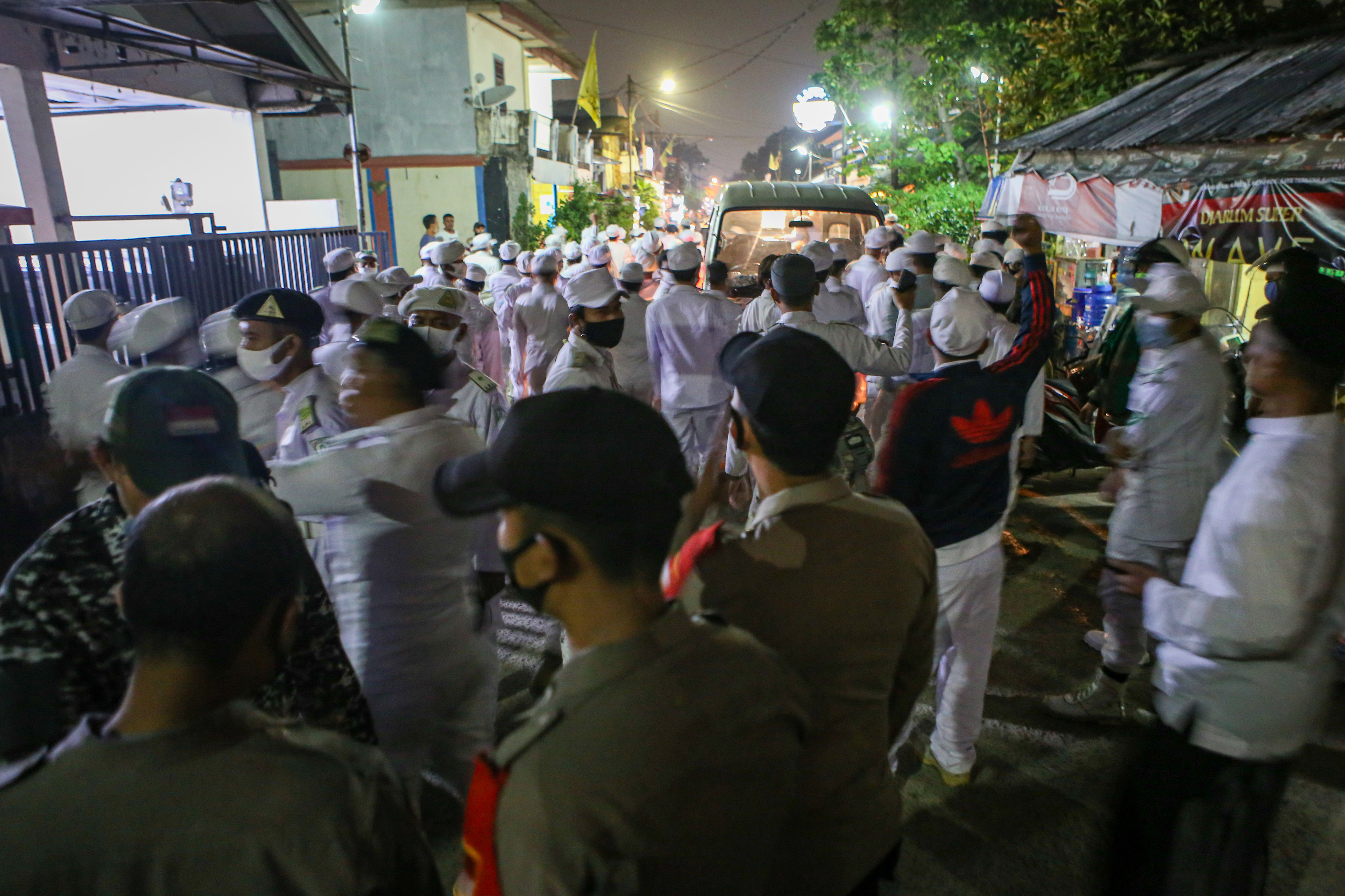 Anggota polisi mengarahkan mobil yang mengangkut anggota Front Pembela Islam (FPI) untuk memutar balik saat hendak memasuki kawasan Bandara 