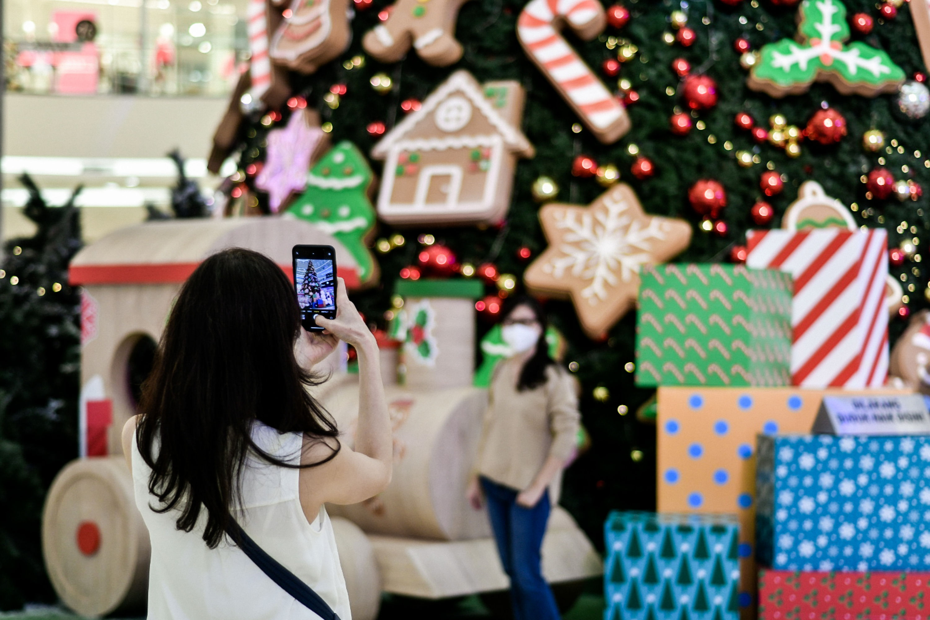 Pengunjung berfoto dengan latar pohon Natal bertema classic Christmas Tree setinggi 18 meter di Senayan City, Jakarta, Senin (21/12).
