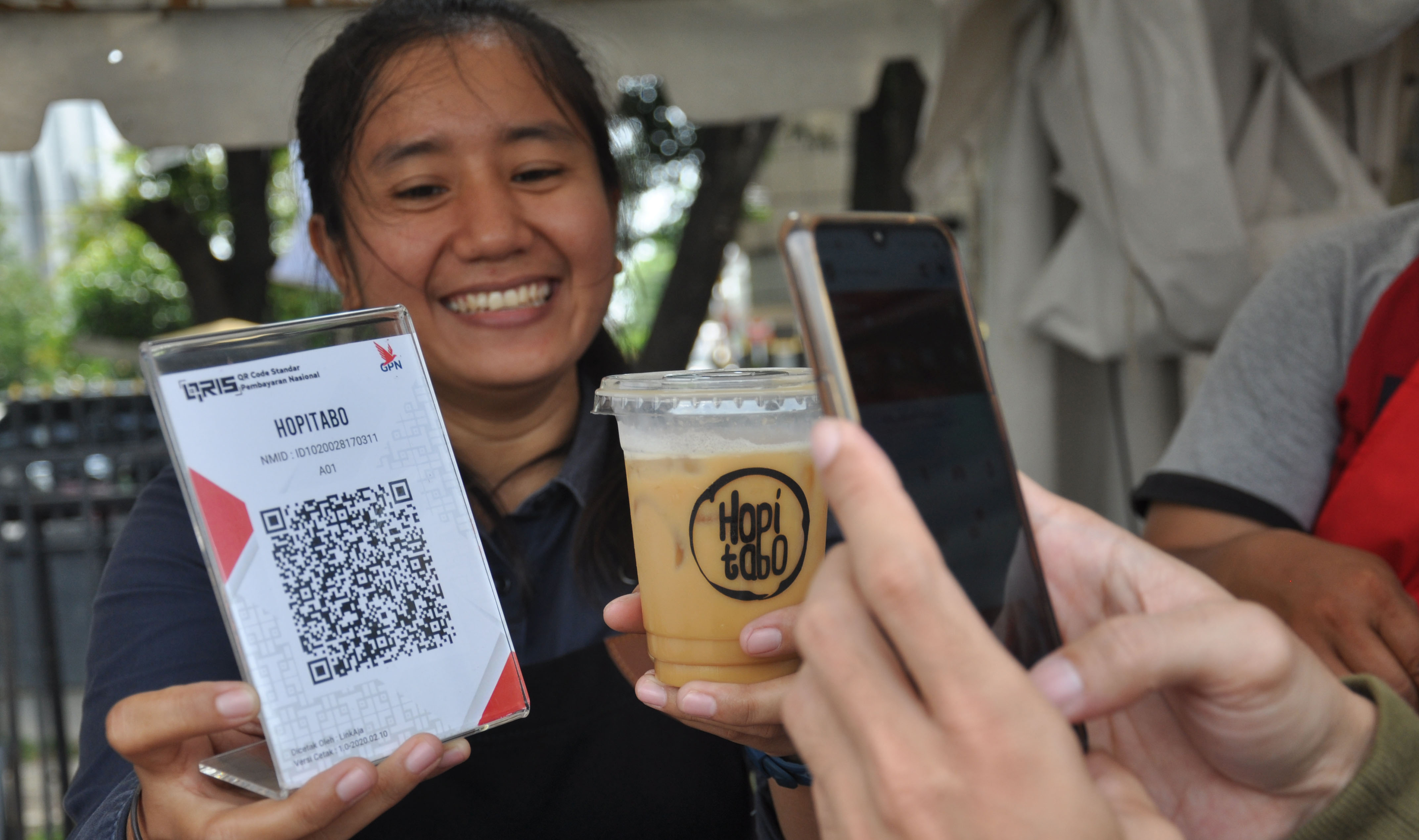 Pembeli membayar kopi melalui scan QR