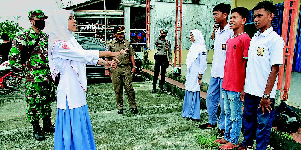 RAZIA PELANGGAR PROTOKOL KESEHATAN: Sejumlah pelajar menyanyikan lagu Indonesia Raya saat terjaring razia pelanggar protokol kesehatan