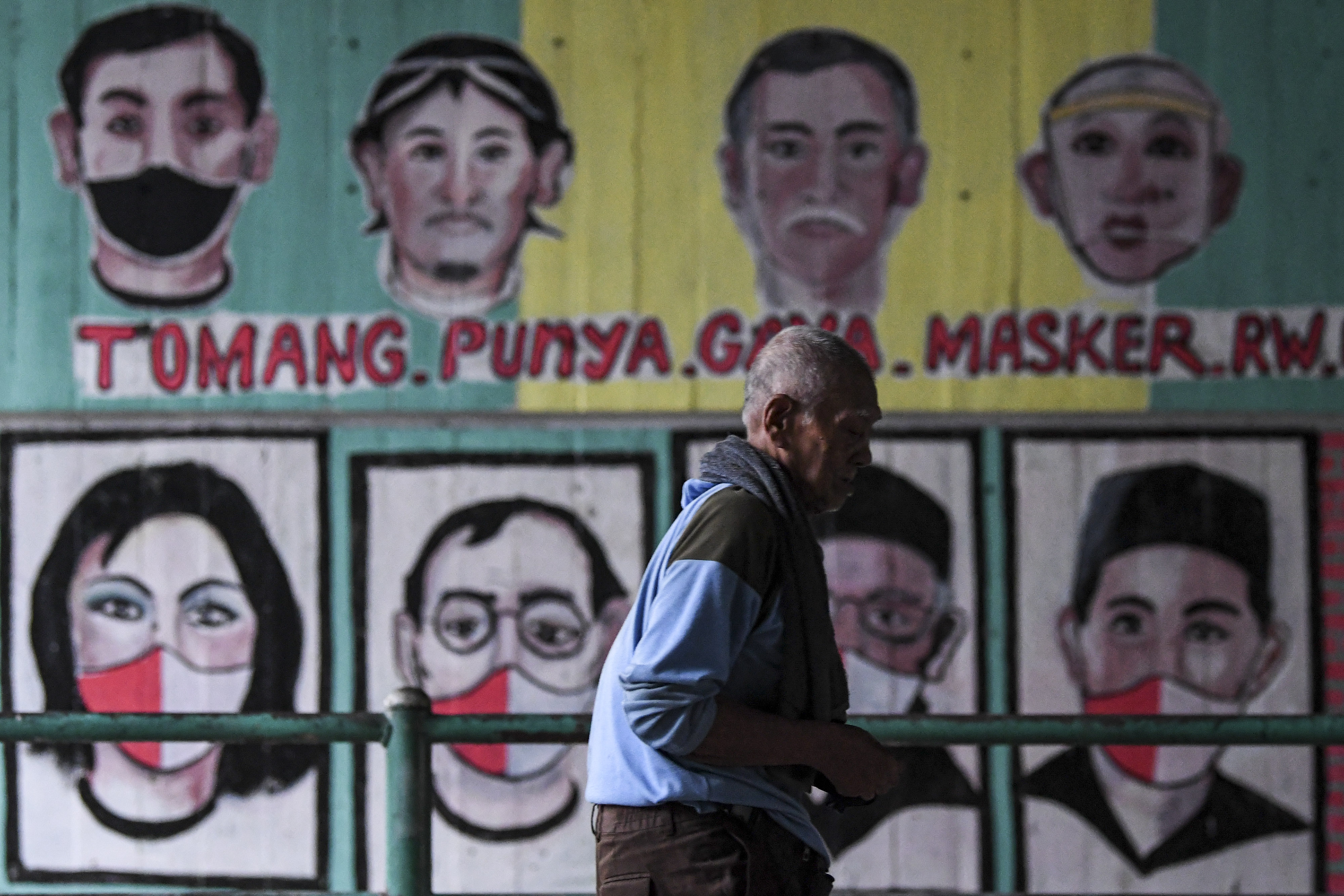 Warga yang tidak mengenakan masker melintas di depan mural berisi pesan ajakan menggunakan masker di Jakarta, beberapa waktu lalu.