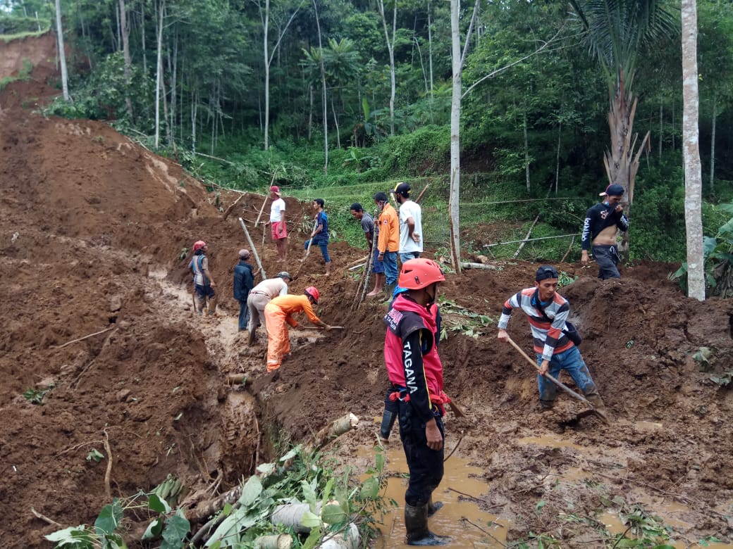 Masyarakat, anggota TNI, Polri, BPBD dan Tagana bergotong royong menyingkirkan material tanah longsor di Tasikmalaya, Jawa Barat. 