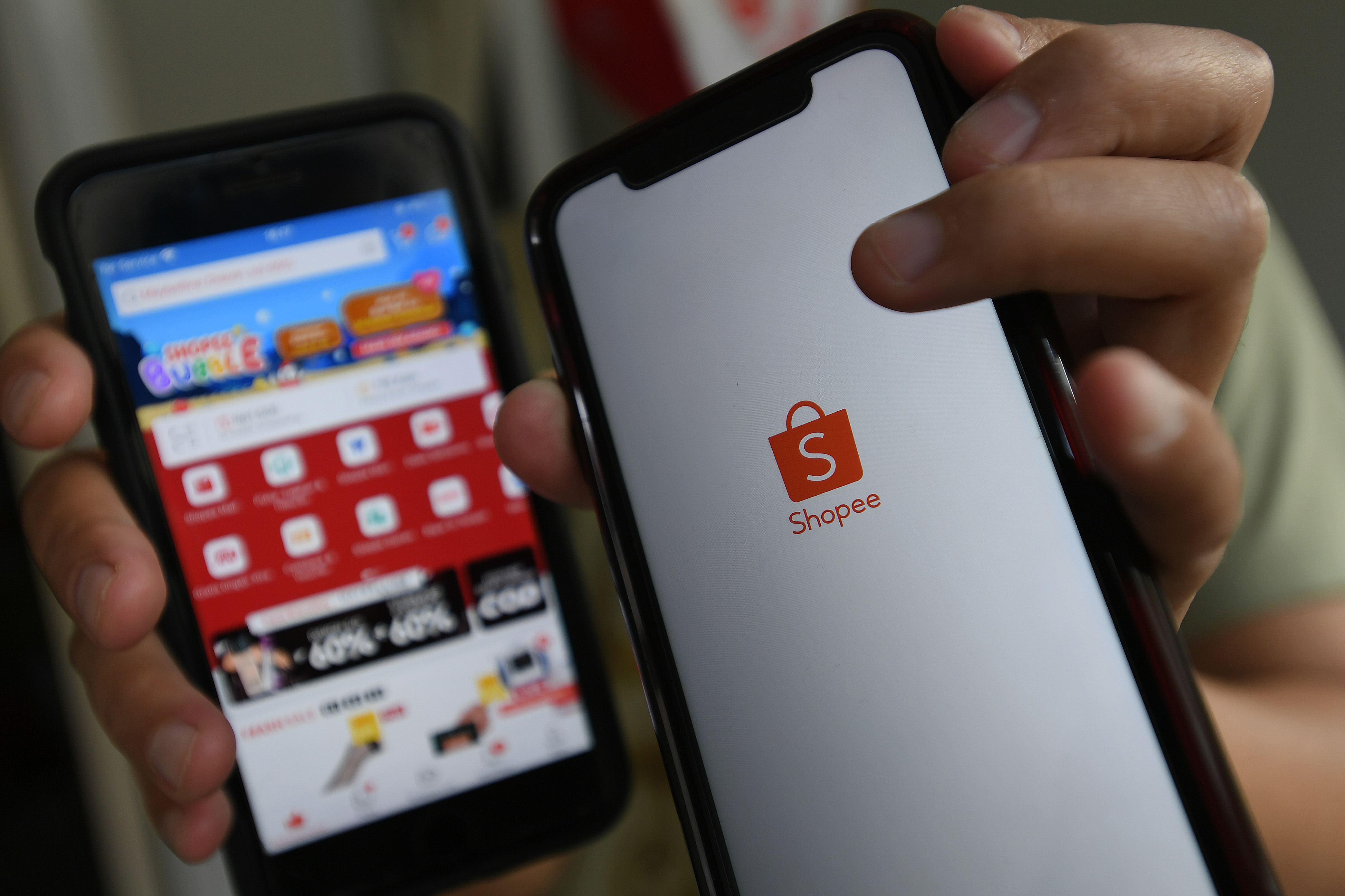 Konsumen menunjukkan aplikasi belanja online Shopee melalui gawai di Jakarta.