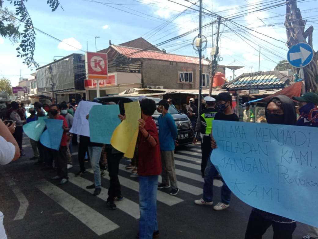 Sekolompok warga menggelar spanduk yang memprotes masjid dijadikan alat politik.