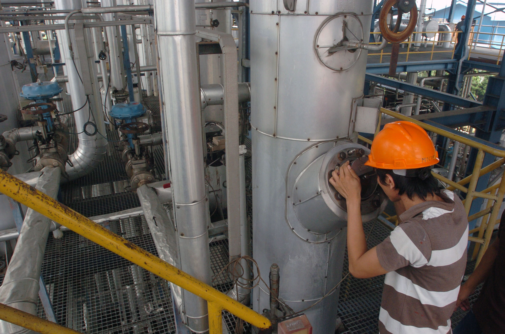 Pekerja memriksa mesin pengolah kelapa sawit