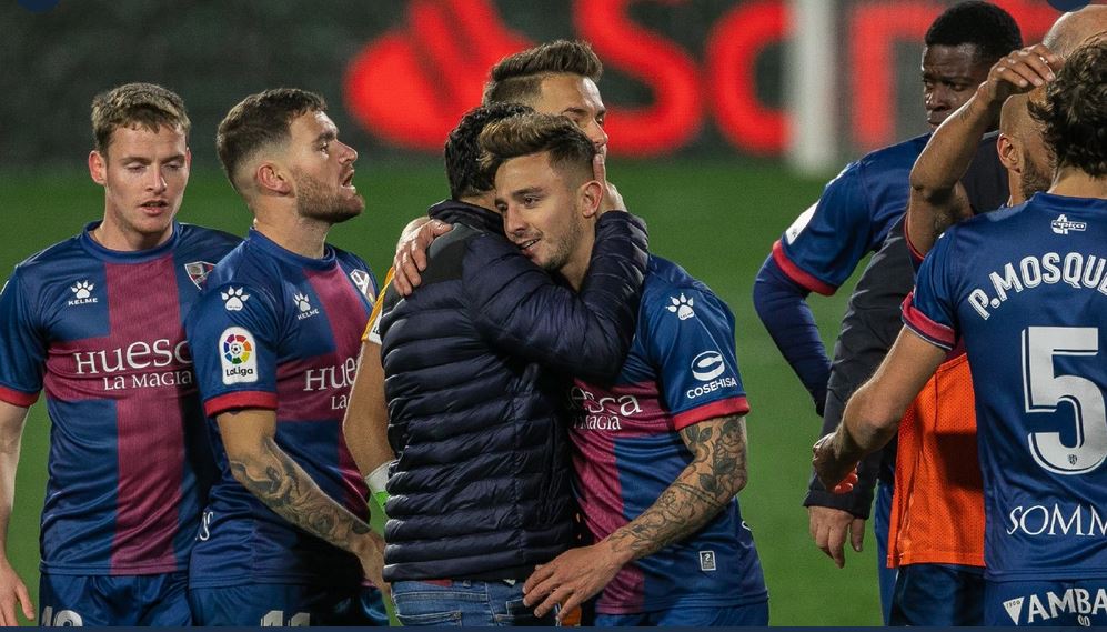 Para pemain dan pelatih Huesca merayakan kemenangan mereka atas Alaves di laga La Liga.