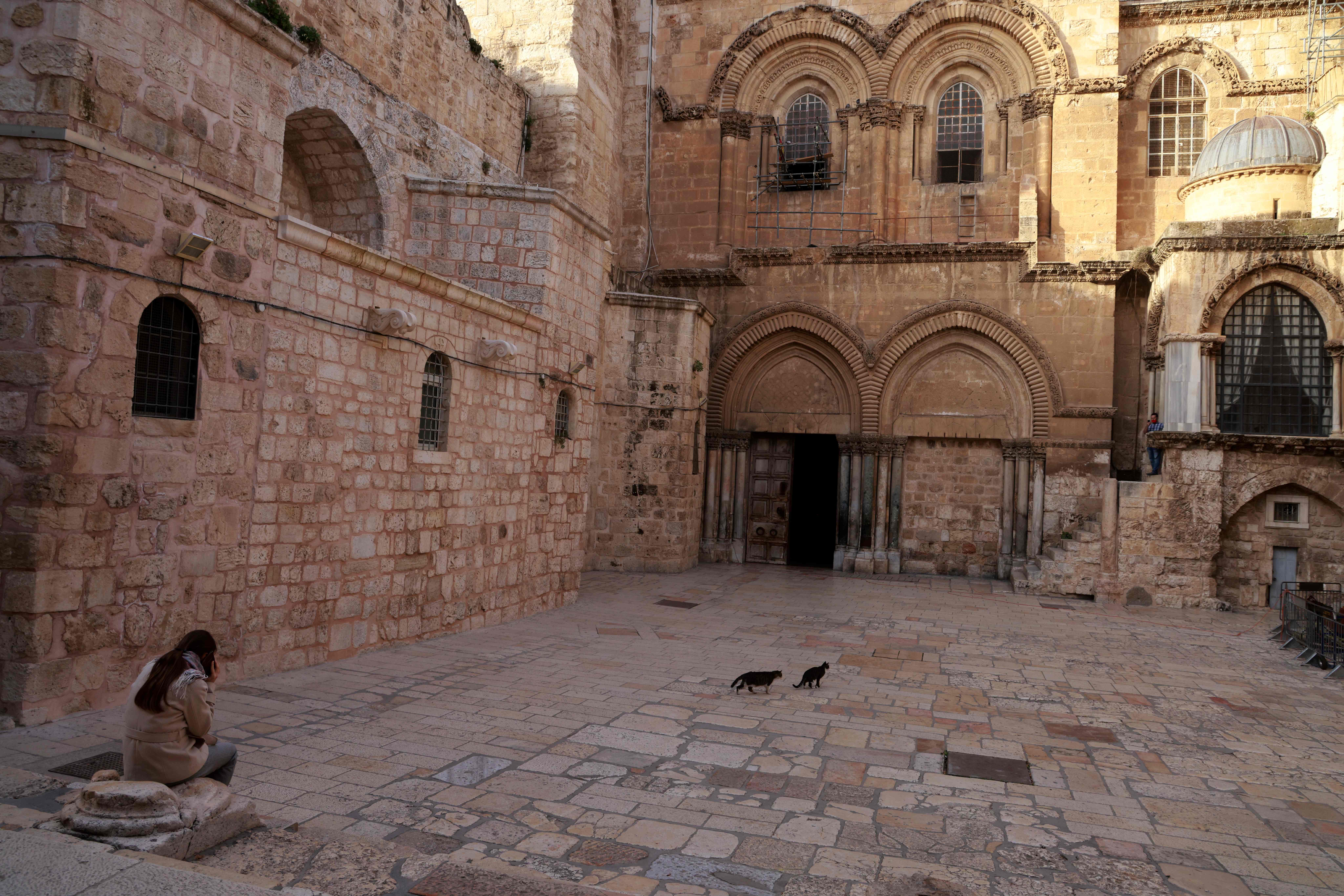 Perempuan duduk di dekat gereja tua di wilayah Palestina yang dikuasai Israel, Senin (28/12/2020).