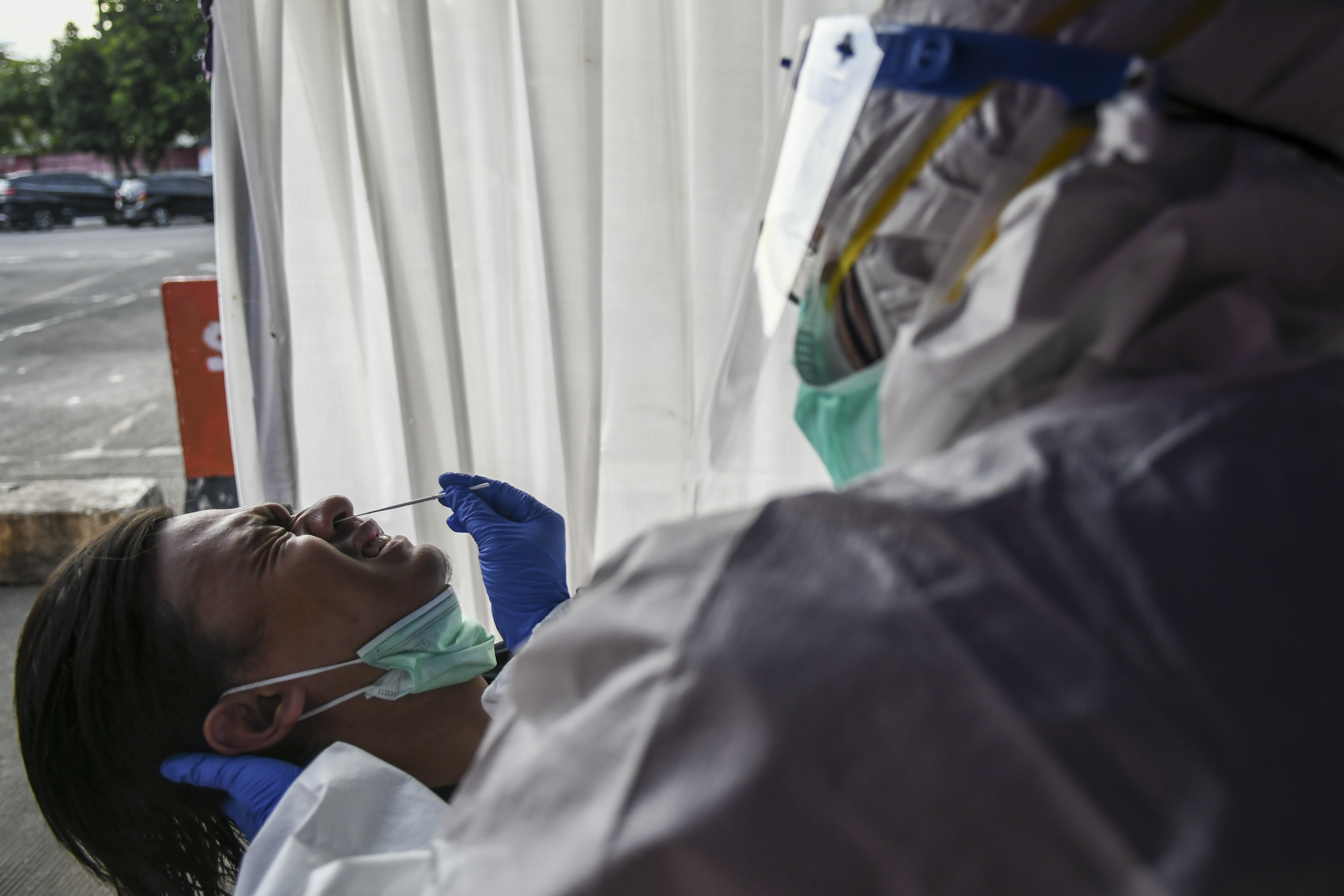 Petugas medis melakukan tes cepat antigen COVID-19 kepada calon penumpang bus Angkutan Kota Antar Provinsi di Terminal Kampung Rambutan