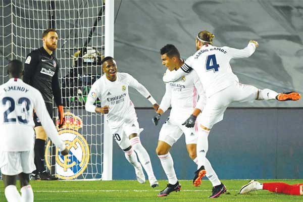 Gelandang Real Madrid Casemiro (tengah) merayakan gol yang dia cetak ke gawang Atletico Madrid
