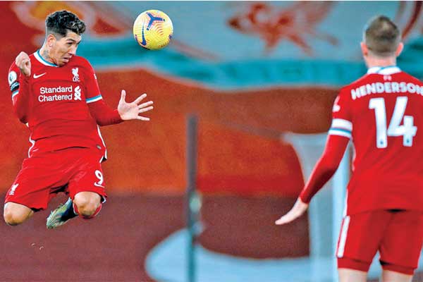 Striker Liverpool Roberto Firmino (kiri) menyundul bola saat timnya tampil melawan Tottenham Hotspur 