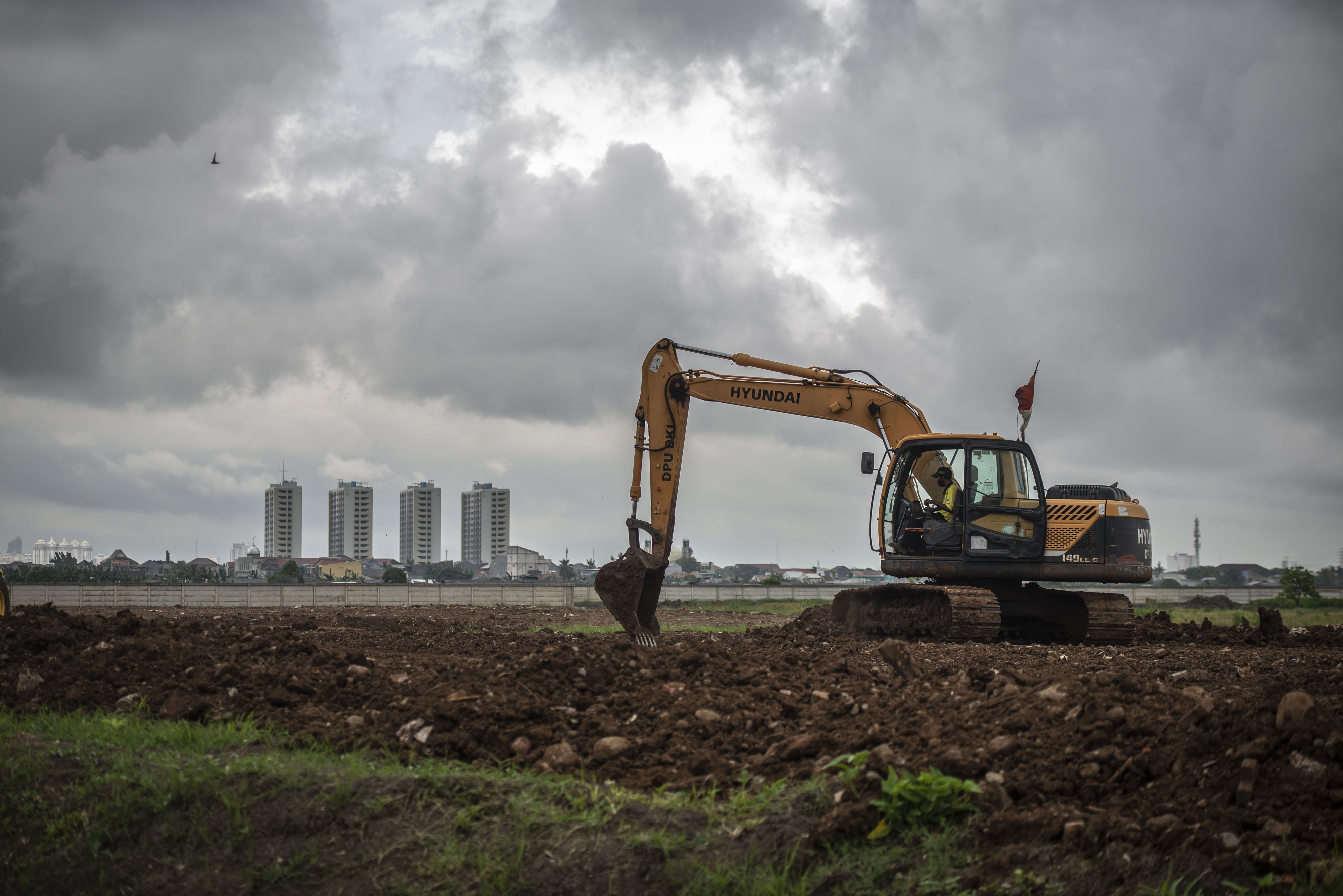  Pekerja dibantu alat berat menyiapkan lahan untuk Tempat Pemakaman Umum (TPU) Rorotan, di Jakarta Utara. 