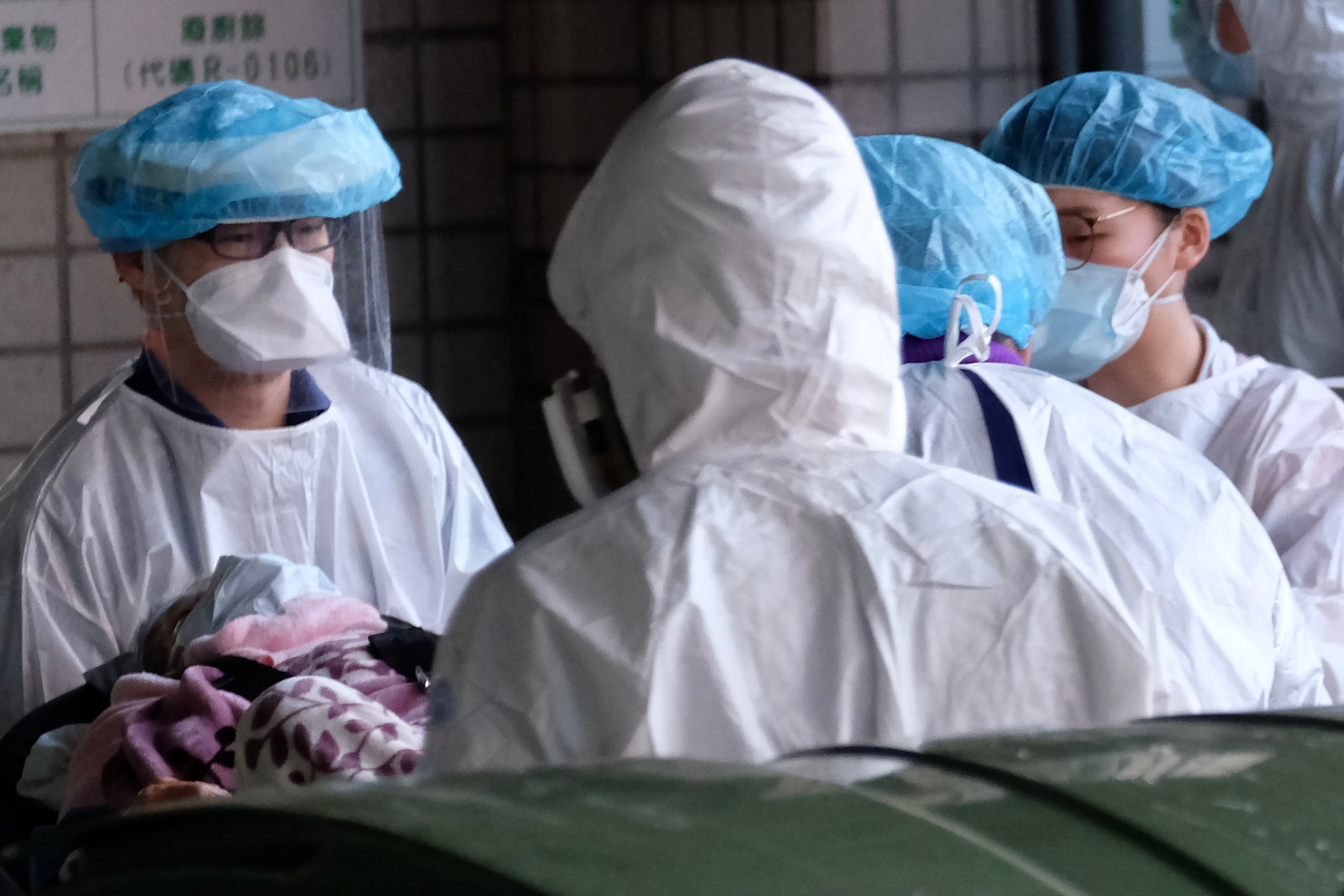 Petugas medis mengantar seorang pasien Covid-19 di Taoyuan General Hospital, Taoyuan, Taiwan, Selasa (19/1).