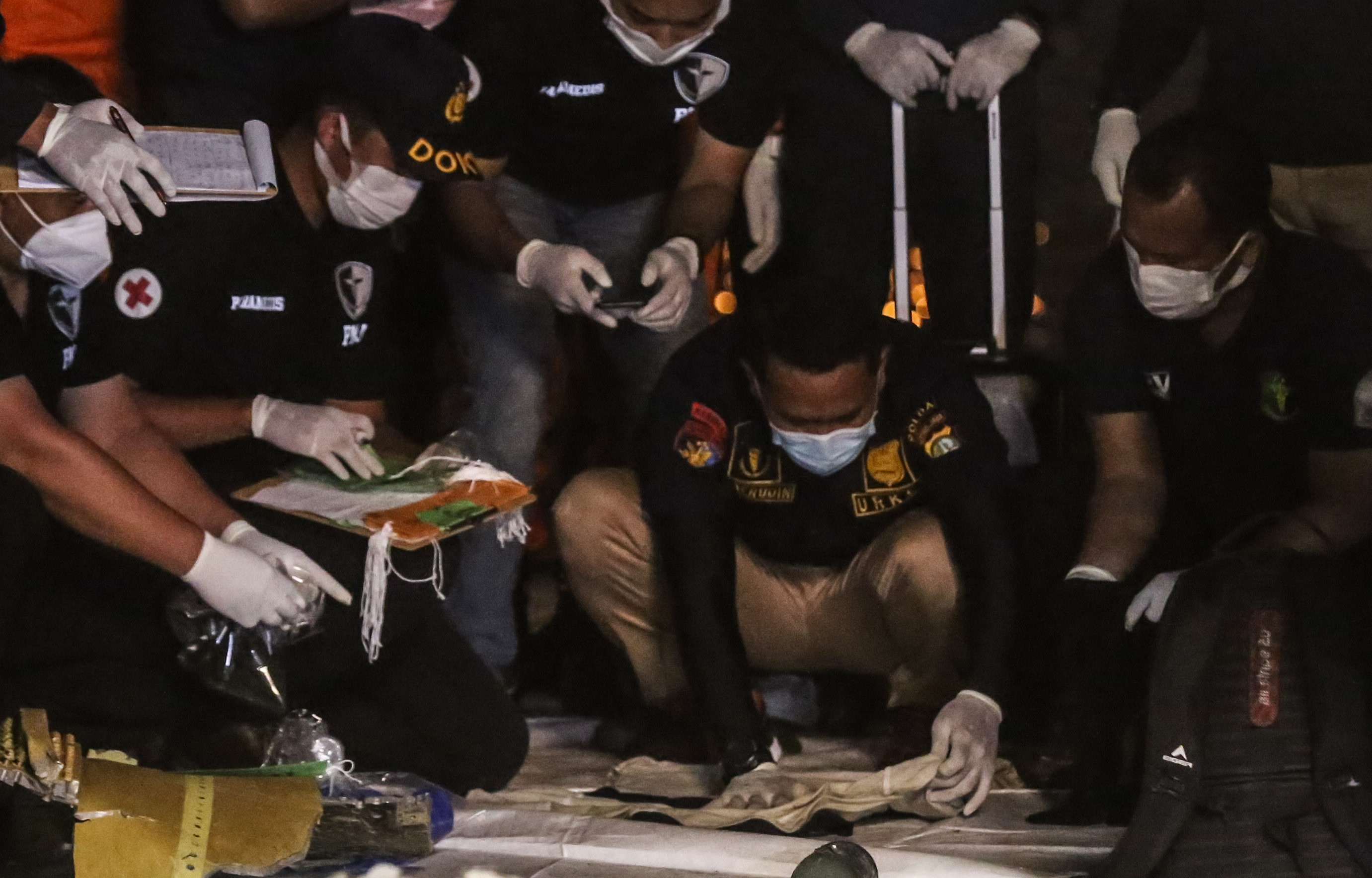 Tim DVI Polri mengidentifikasi pakaian yang diduga milik korban pesawat Sriwijaya Air SJ 182 di Dermaga JICT, Tanjung Priok, Jakarta Utara.