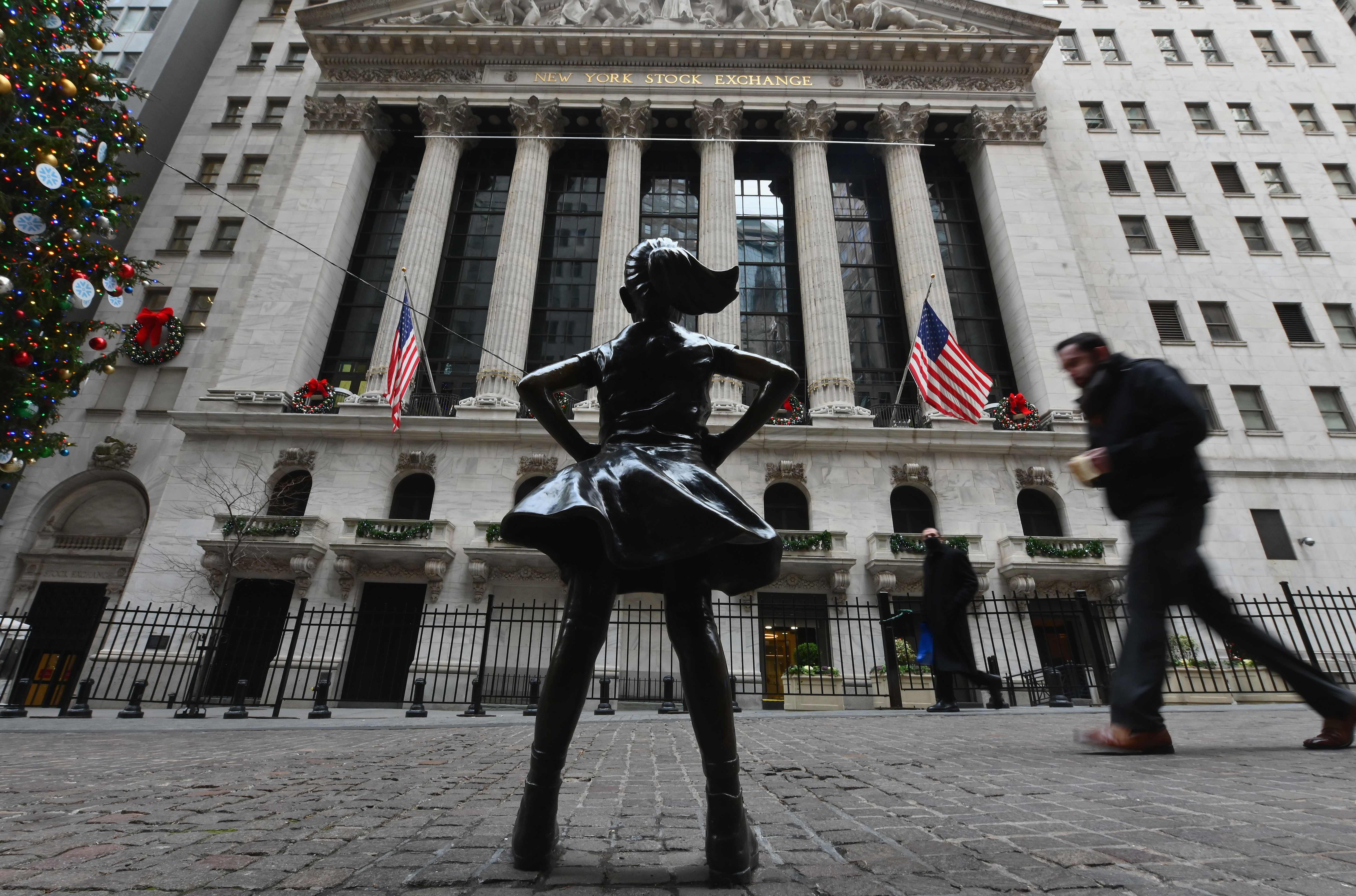 Warga berjalan di depan bursa saham new York atau Wall Street