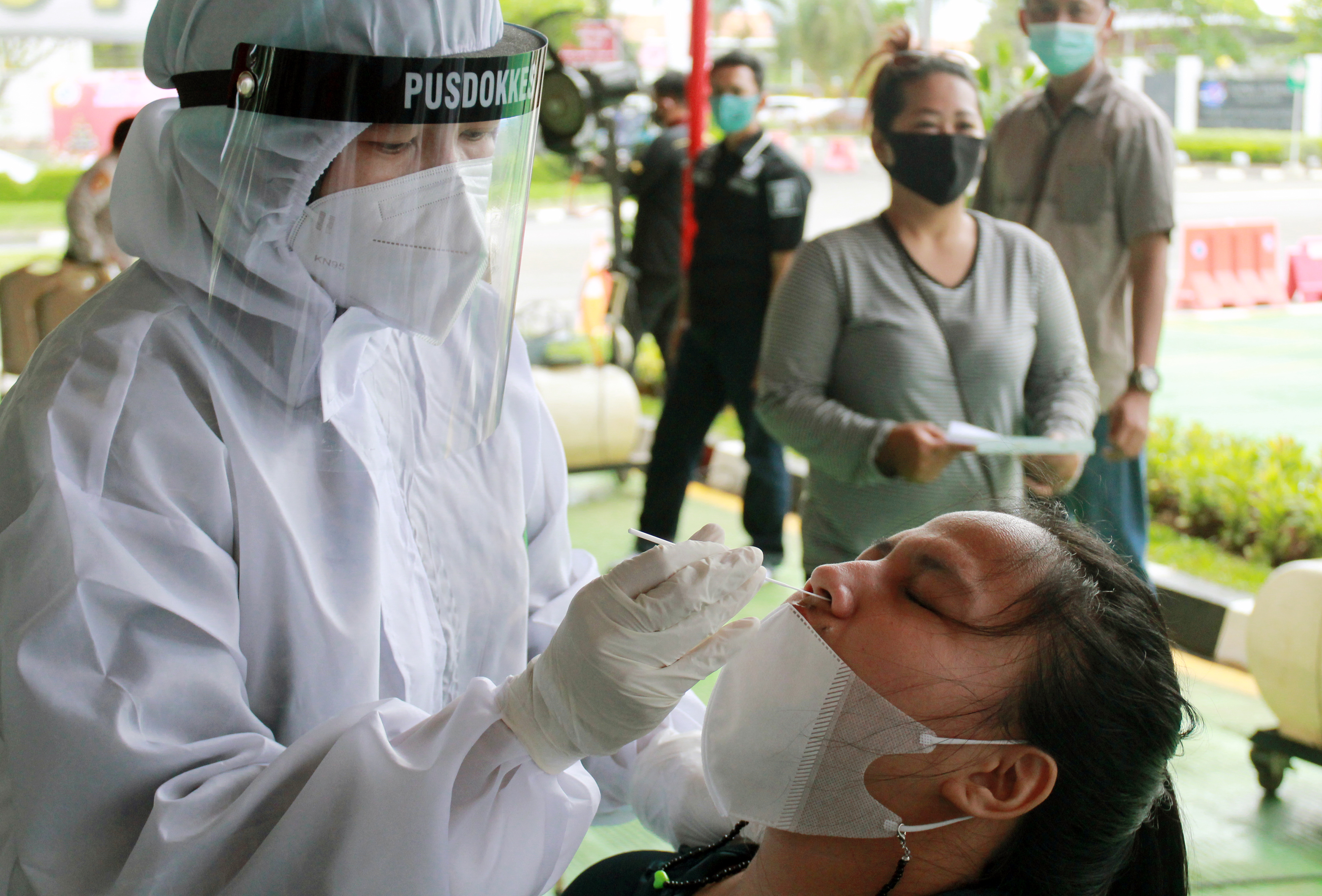 Petugas kesehatan dari Pusdokkes Bandara Soekarn- Hatta melakukan rapid test antigen kepada warga di Tangerang, Banten.