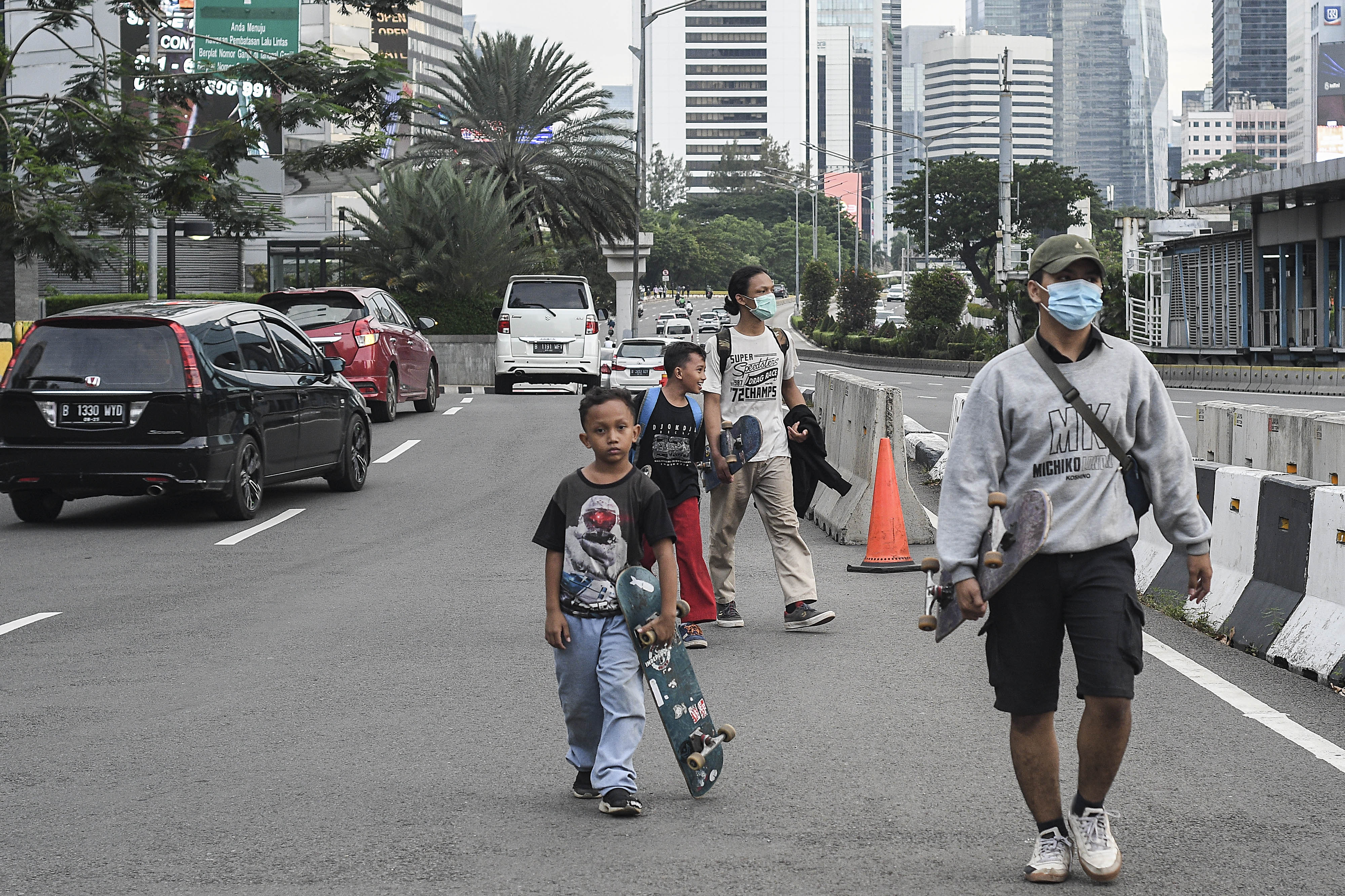 Dua anak tidak menggunakan masker saat melintas di daerah Sudirman, Jakarta, Sabtu (16/1/2021).