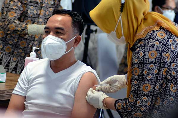 Tenaga kesehatan menyuntikan vaksin COVID-19. 