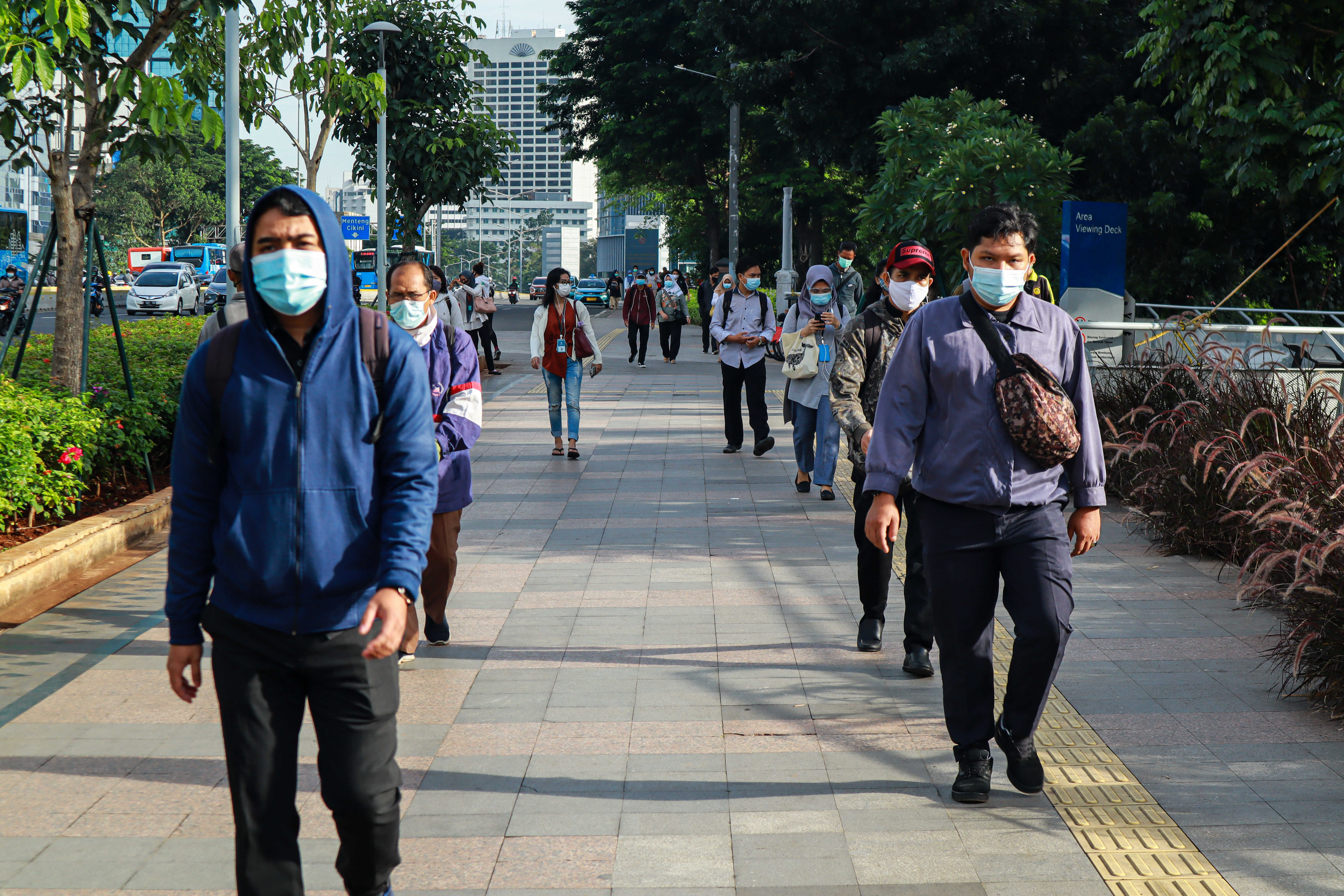 Pekerja berjalan di kawasan Jenderal Sudirman, Jakarta, Senin (4/1)