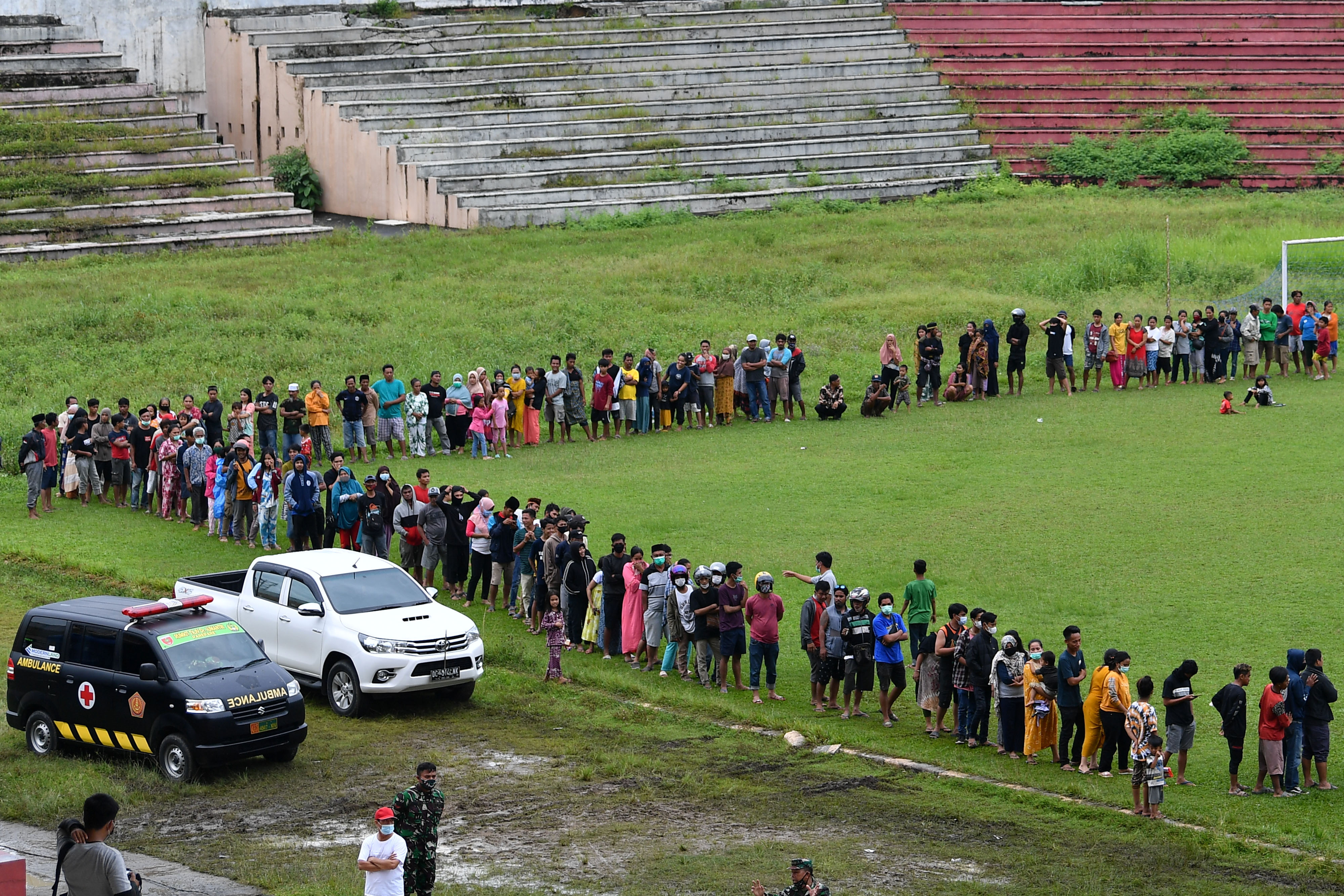 Pengungsi korban gempa antre untuk mendapatkan bantuan logistik dari TNI AD di Stadion Manakarra, Mamuju, Sulawesi Barat, kemarin.