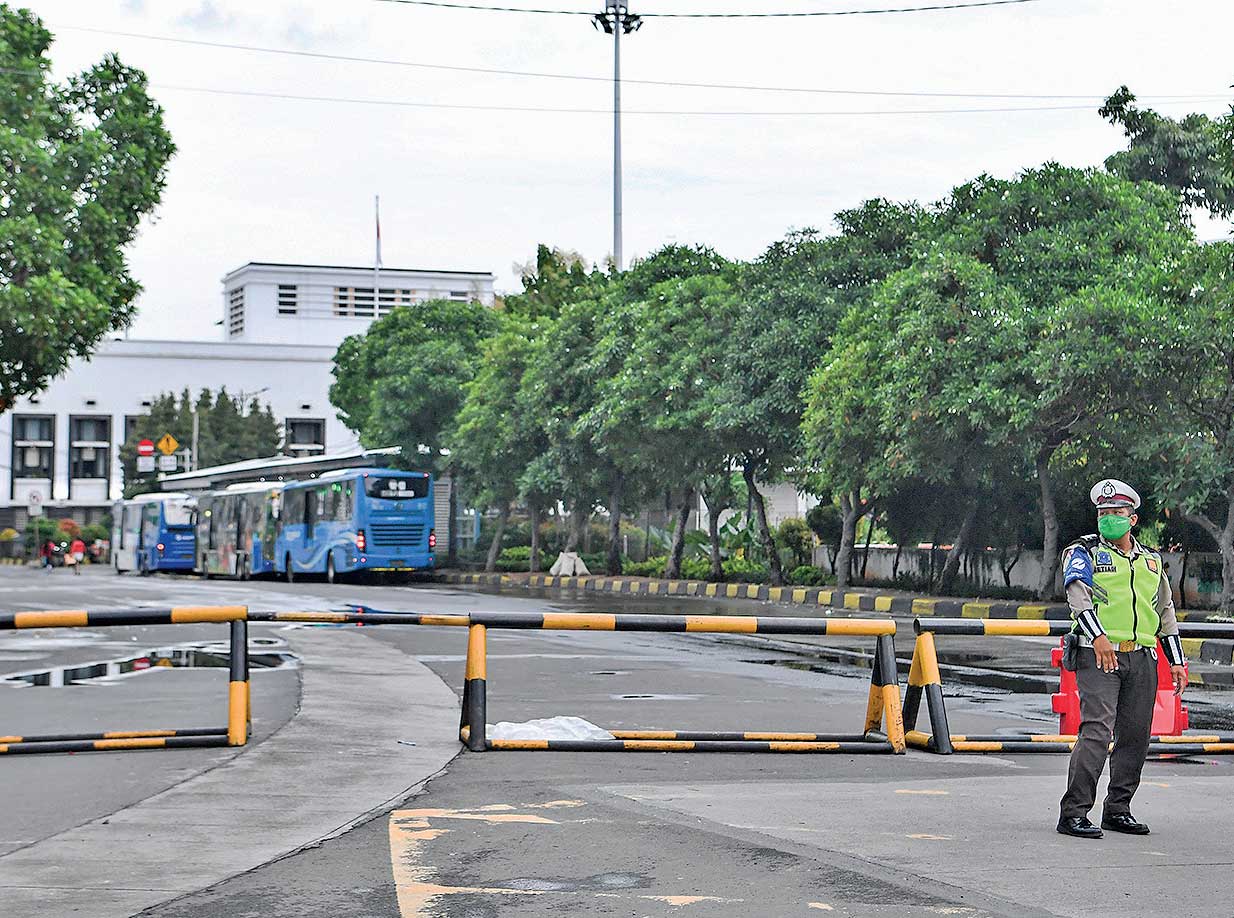 PENERAPAN PPKM: Polisi berjaga di depan Jalan Pintu Besar Utara yang ditutup di kawasan Kota Tua, Jakarta, kemarin