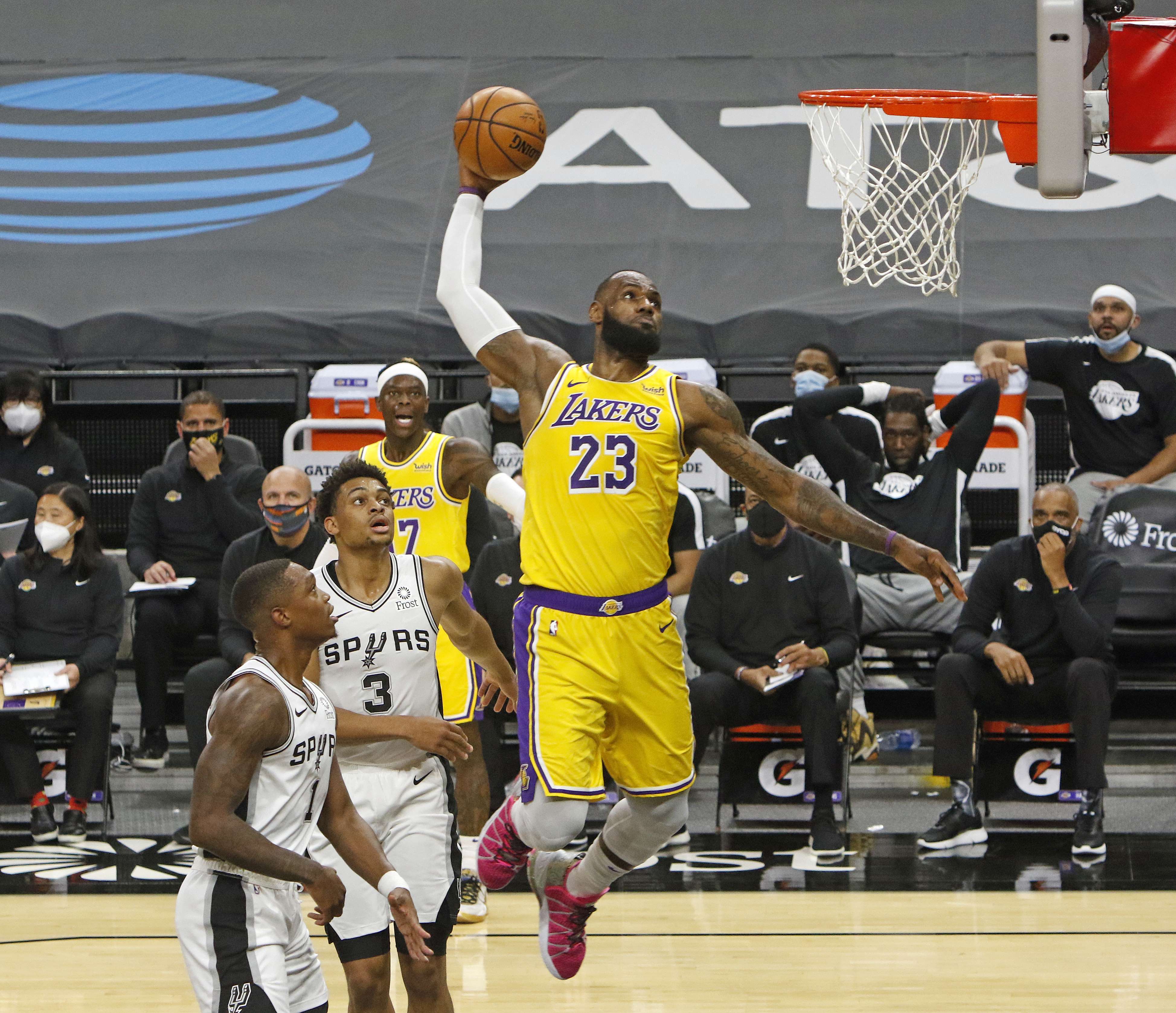 Aksi LeBron James dari LA Lakers (kiri) melakukan dunks saat timnya melawan San Antonio Spurs. 