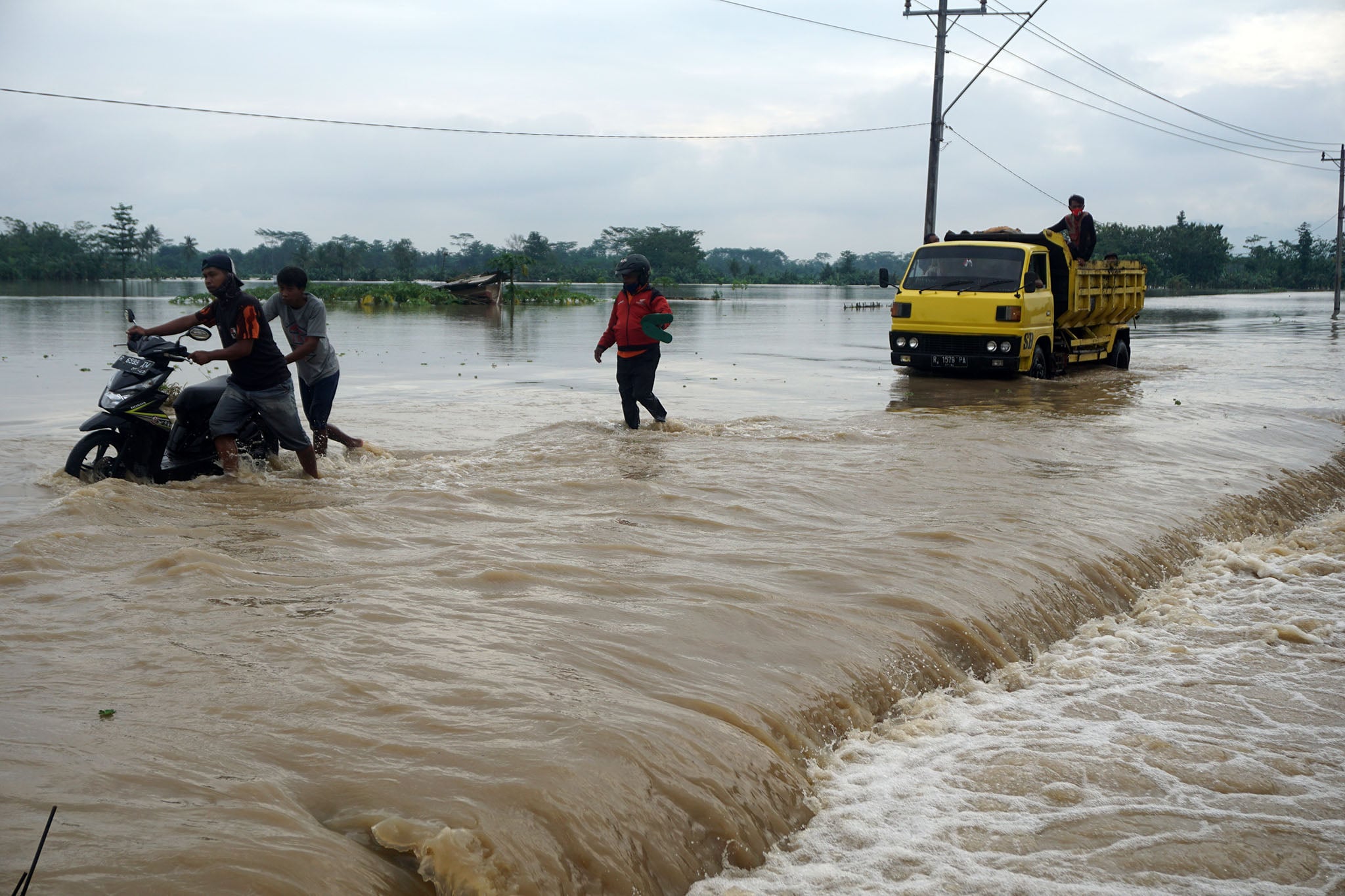 Sejumlah kendaraan harus didorong akibat banjir di jalan penghubung antara Kabupaten Banyumas dan Purbalingga, Jawa Tengah. 