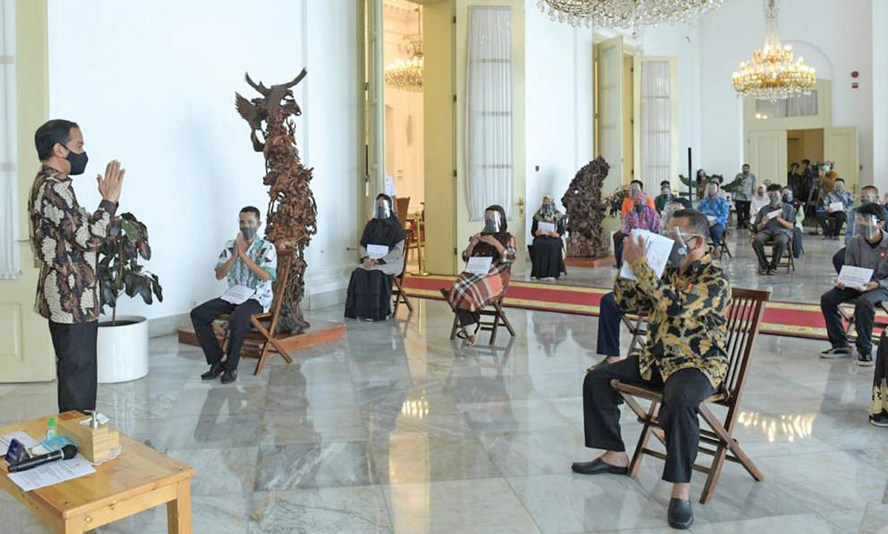 Presiden Joko Widodo memberikan salam saat penyaluran bantuan modal kerja (BMK) kepada pelaku usaha UMKM serta pedagang di Istana Bogor.