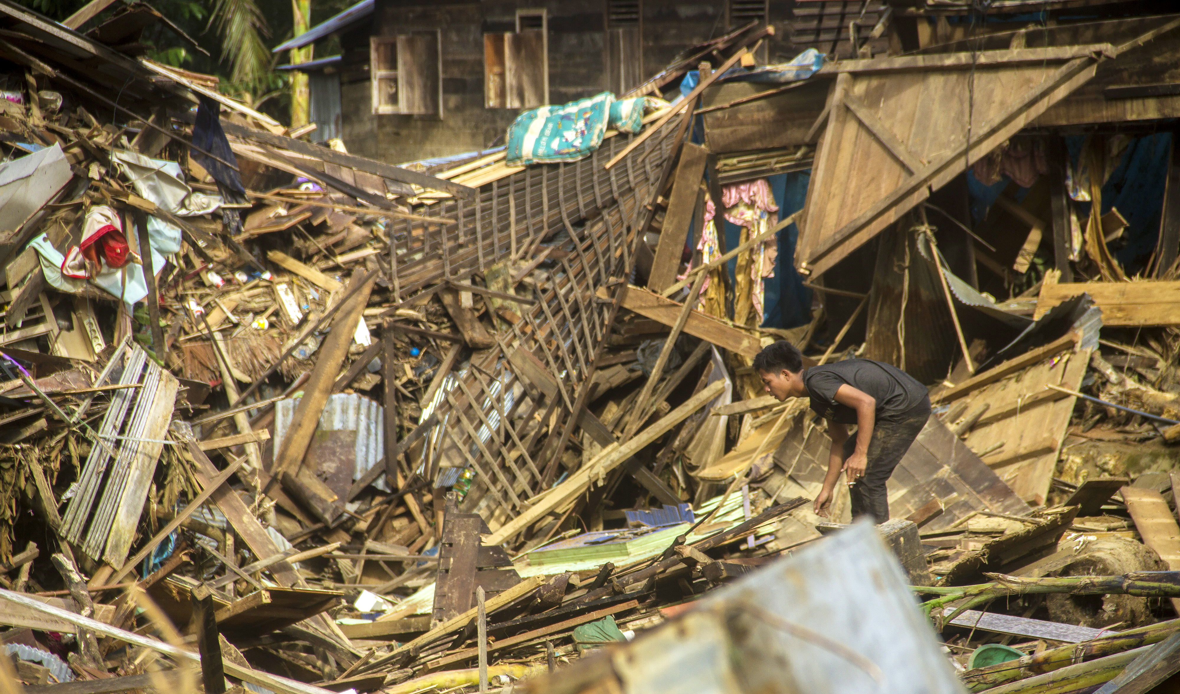 warga berada di puing-puing rumah akibat banjir bandang di Desa Waki, Kecamatan Batu Benawa,Kabupaten Hulu Sungai Tengah, Kalimantan Selatan