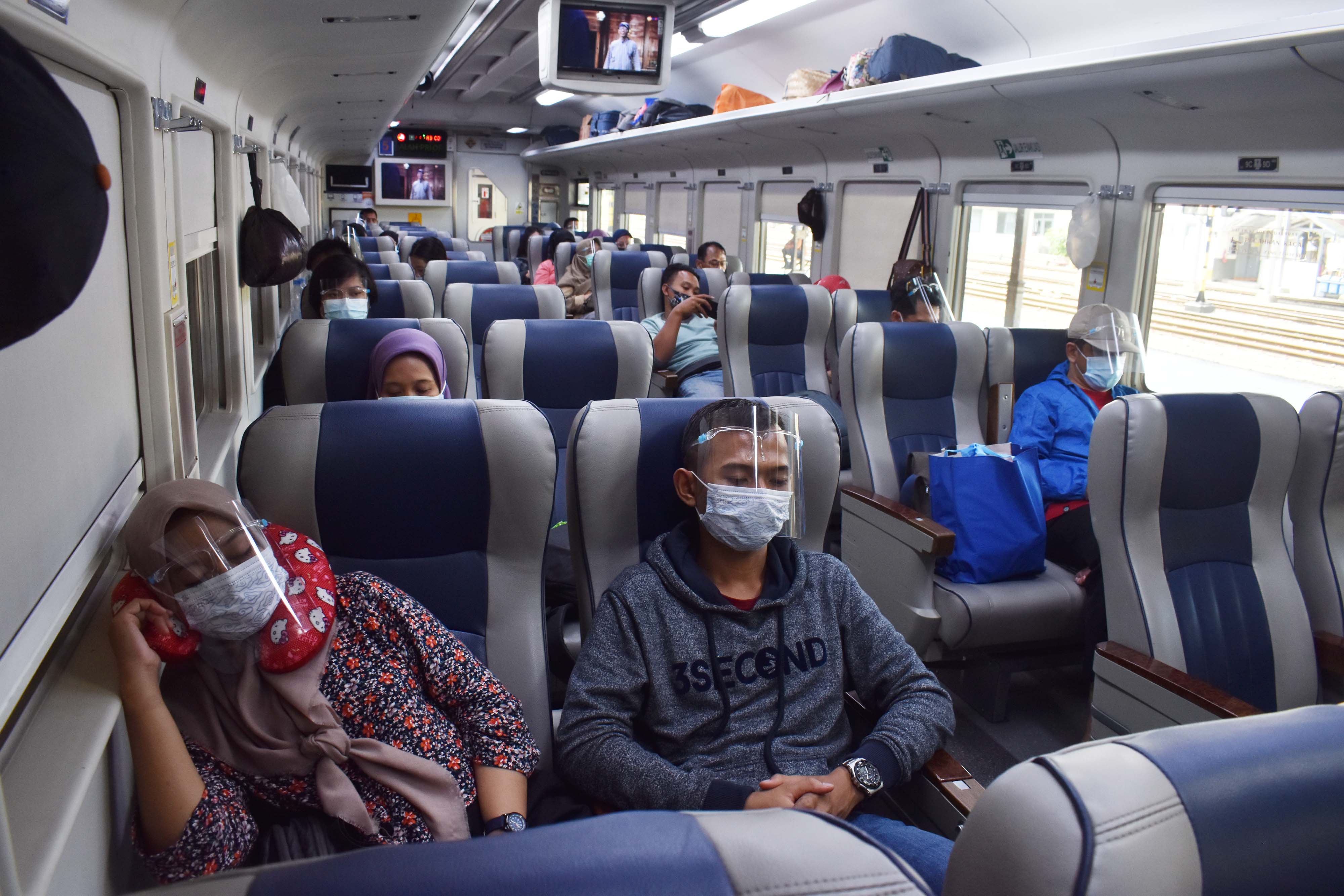 Penumpang  di dalam KA Ranggajati jurusan Cirebon-Purwokerto-Banyuwangi saat arus balik Nataru di Stasiun KA Madiun, Minggu (27/12/2020).