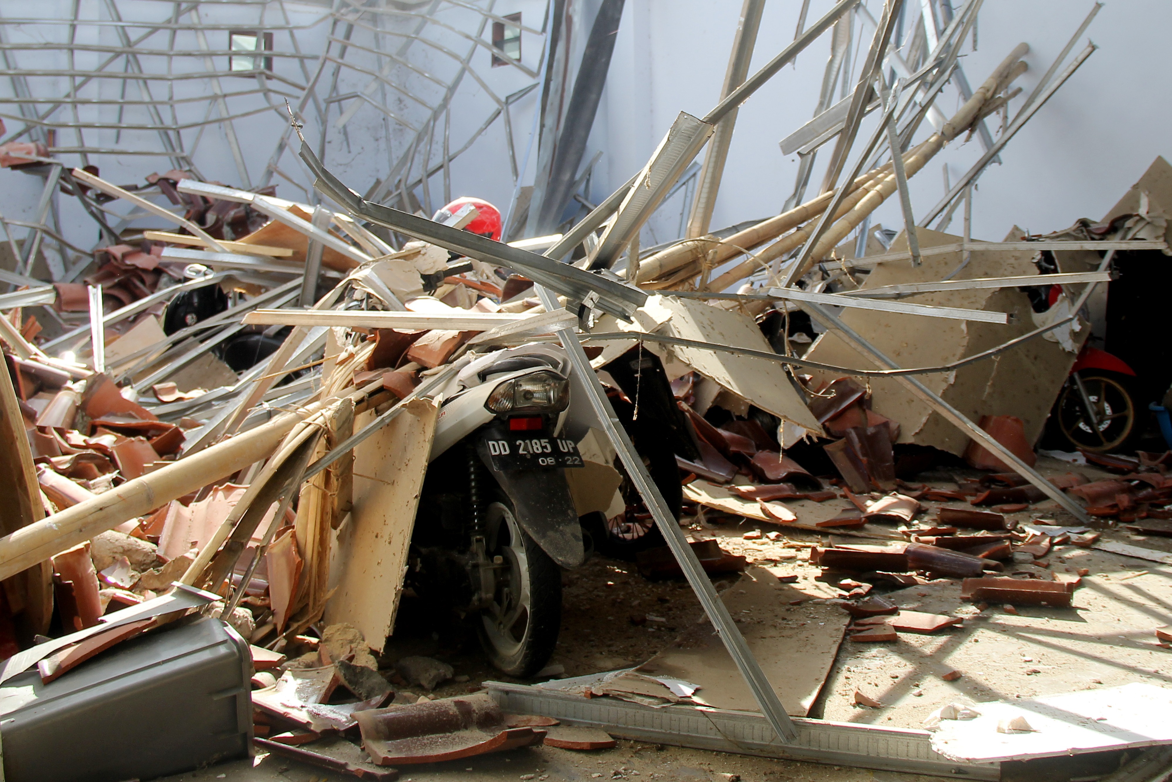 Warga memotret atap rumah yang ambruk akibat gempa bumi di Mamuju, Sulawesi Barat.