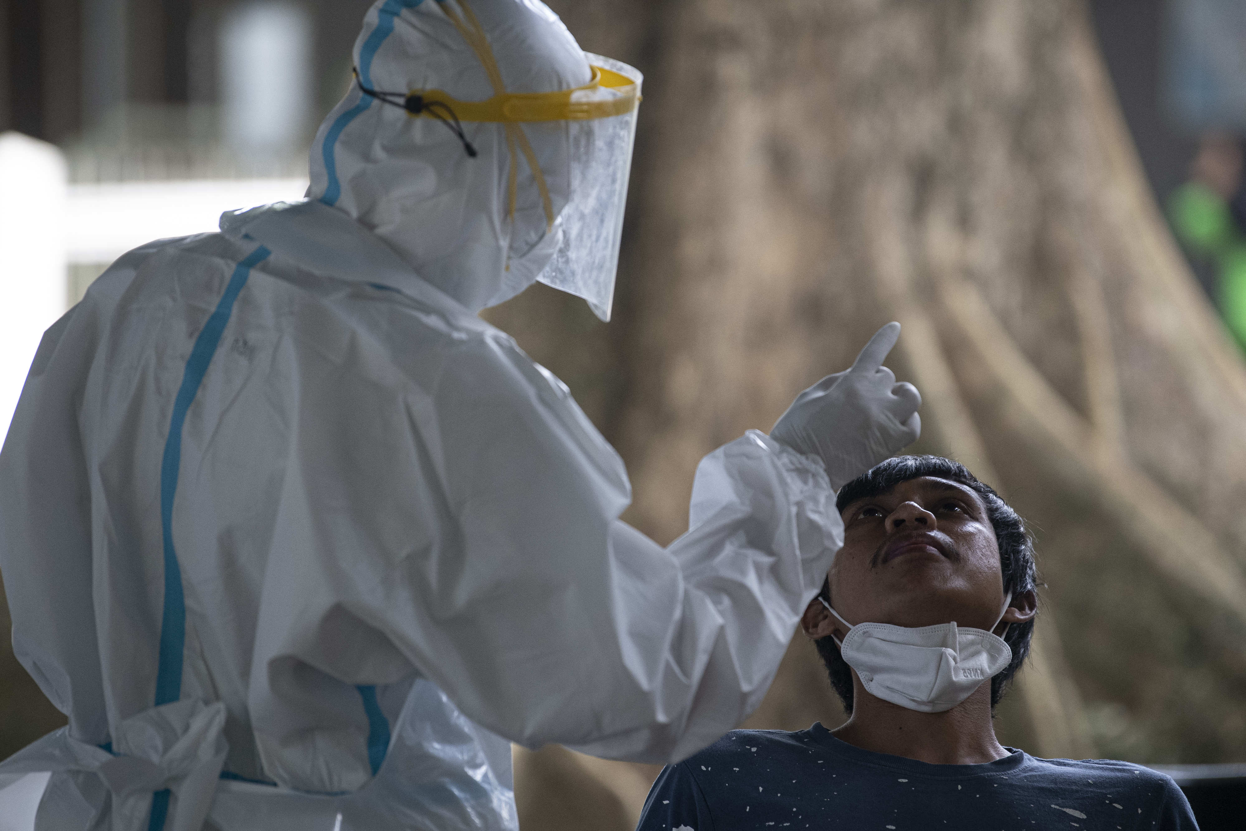 Petugas mengambil sampel lendir dari hidung warga saat tes usap PCR  di RS Umum Pusri Palembang, Sumatra Selatan, Senin (25/1)