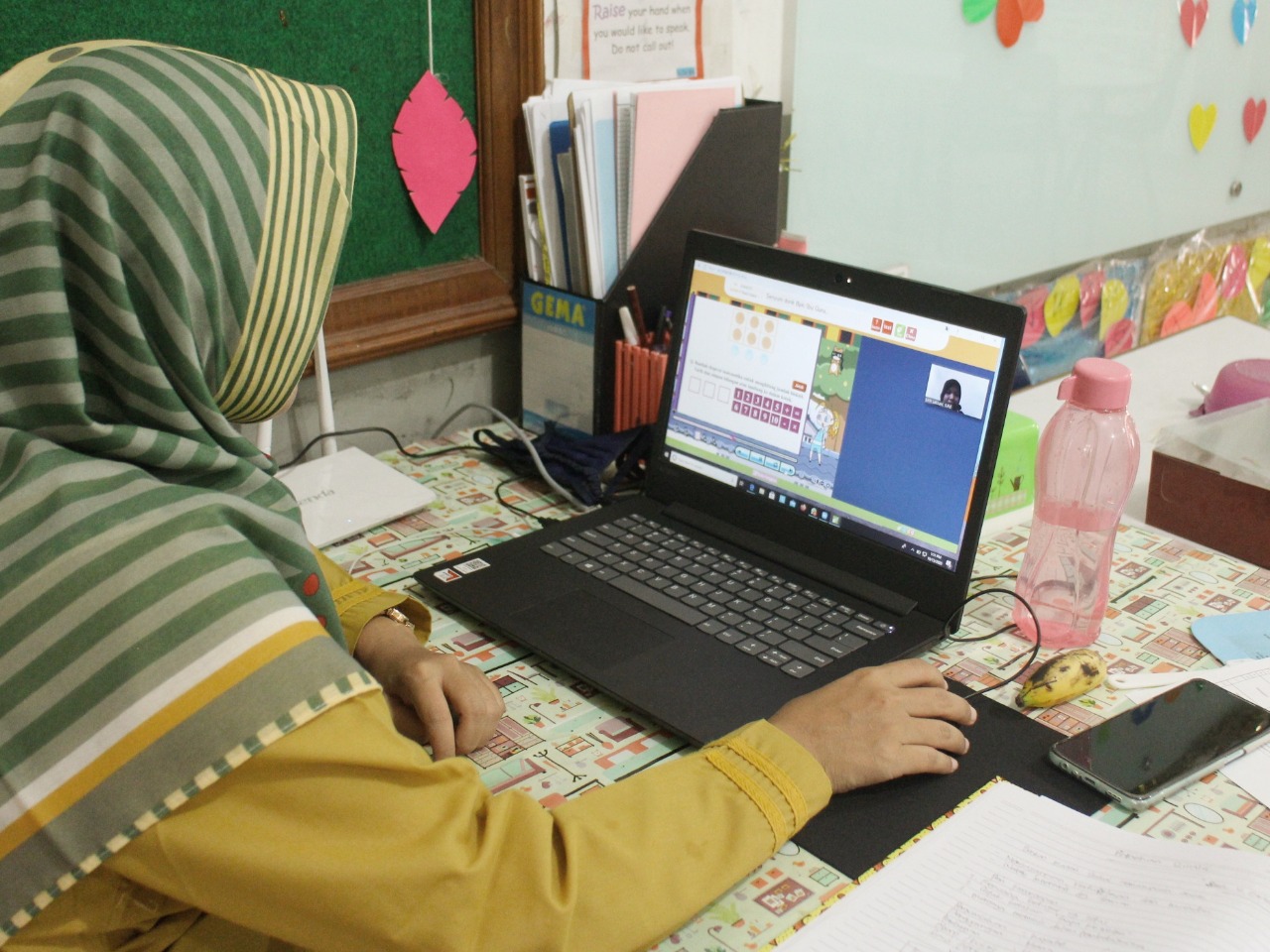 Seorang guru SD sedang melakukan pembelajaran jarak jauh secara daring dengan para siswa.