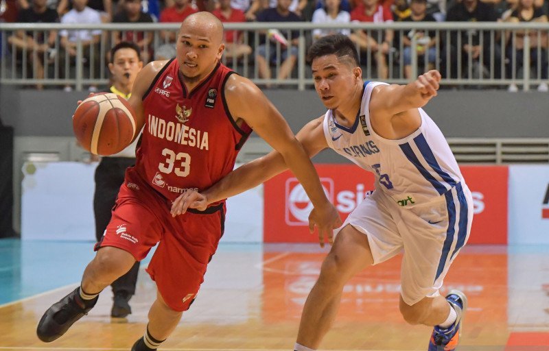 Pebasket Indonesia Arki Dikania Wisnu (kiri) dihadang pebasket Filipina Roger Pogoy (kanan) dalam kualifikasi FIBA Asia Cup 2021 grup A. 