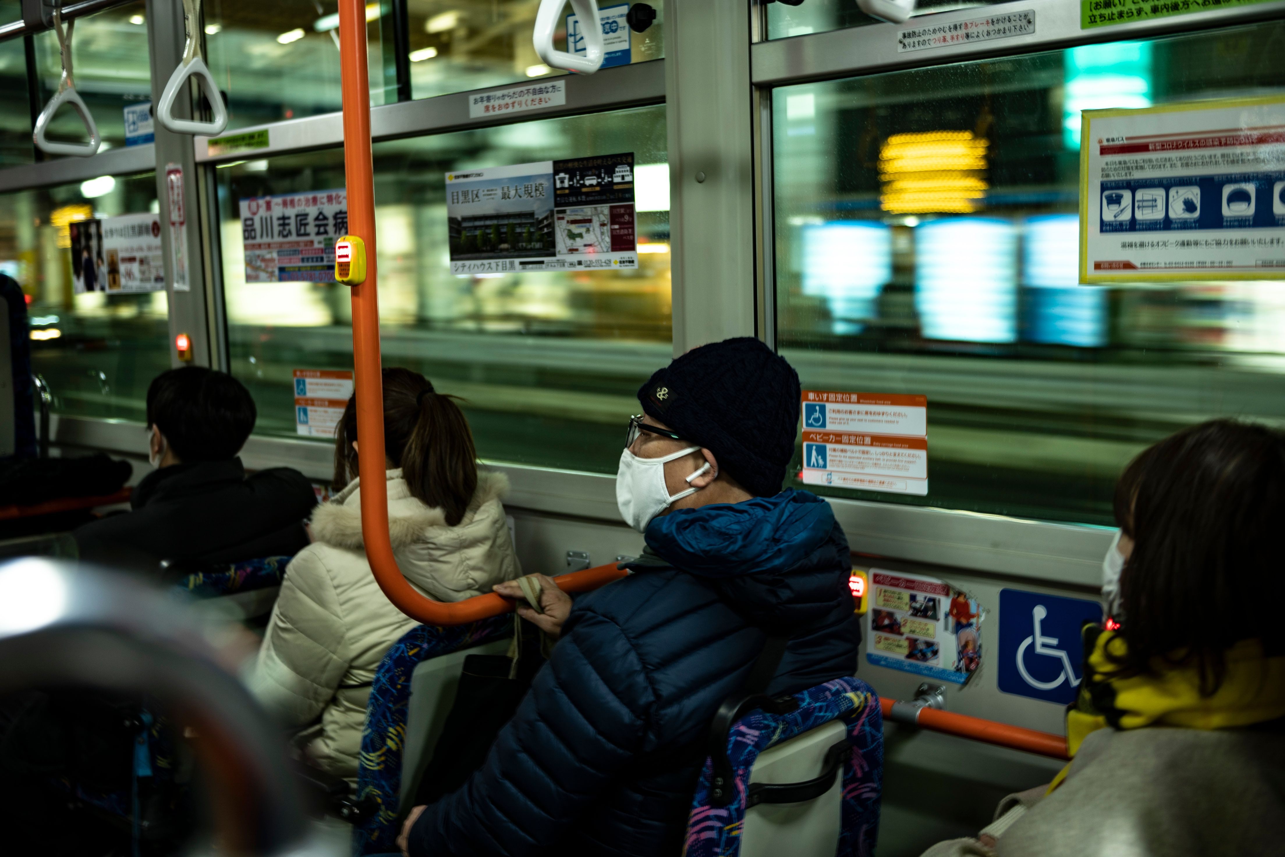 Penumpang melakukan perjalanan dengan bus di Tokyo pada Jumat (8/1) selama hari pertama dalam keadaan darurat.