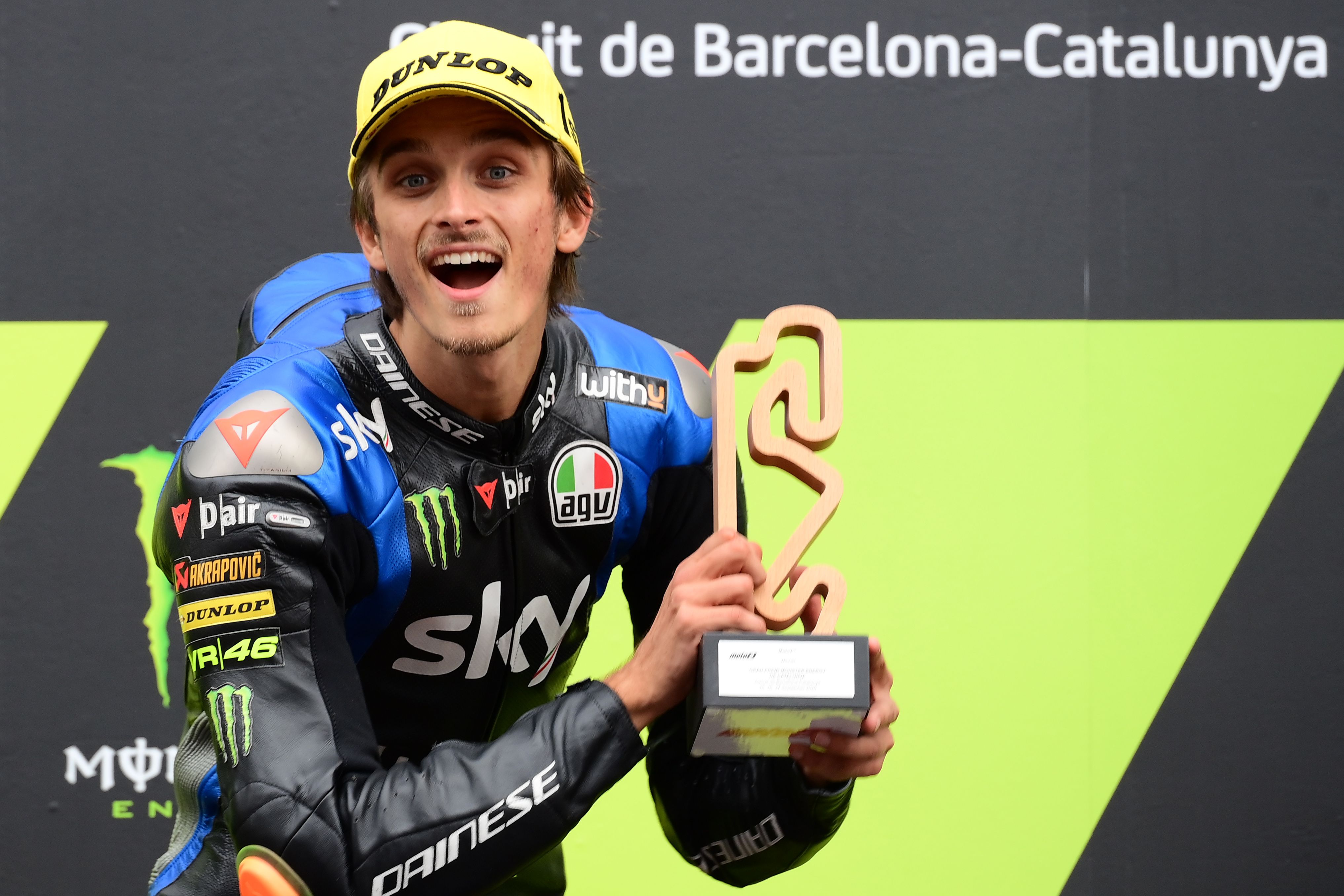 Luca Marini, adik Valentino Rossi, mengangkat trofi saat menjuarai Moto2 di Sirkuit de Catalunya, Montmelo, Spanyol, pada September 2020. 